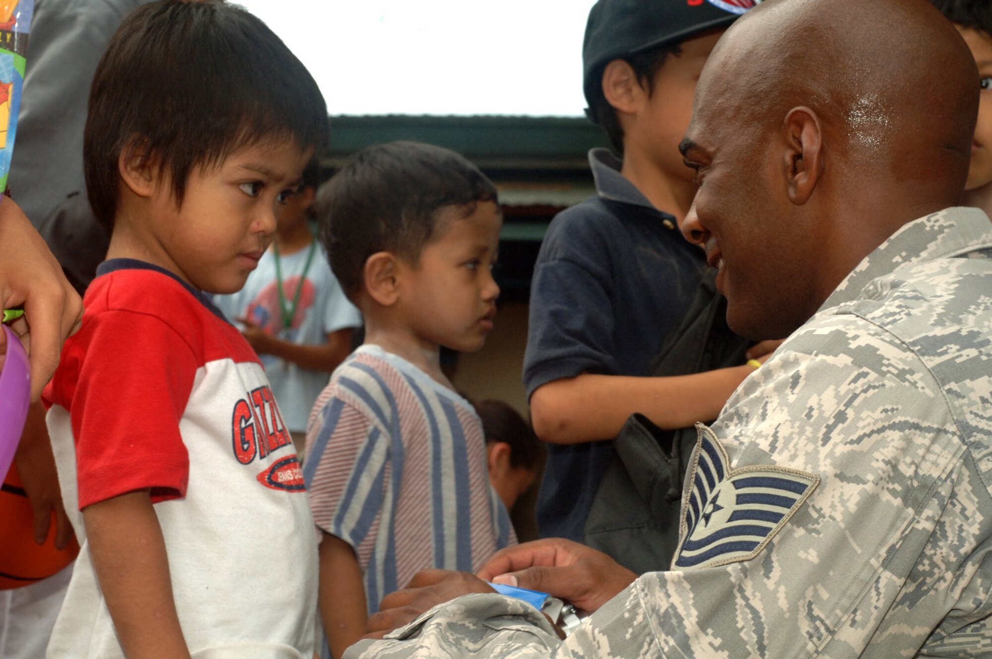 Tech. Sgt. Derek Smith of the 56th Logistics squadron, at Luke Air Force Base, Ariz., and more than 20 other Airmen hand out donated school supplies, athletic equipment and toys to Filipino children from the Duyan Ni Maria orphanage as part of a volunteer community relations event here April 24-25. United States and the Republic of the Philippine military forces are participating  in Balikatan 2009, an annual joint bilateral exercise designed to improve United States and the Republic of the Philippines combined planning, combat readiness and interoperability for a wide range of operations, from humanitarian assistance to peacekeeping missions throughout the region. (Marine Corps photo/ Petty Officer Second Class Robert Clowney)
