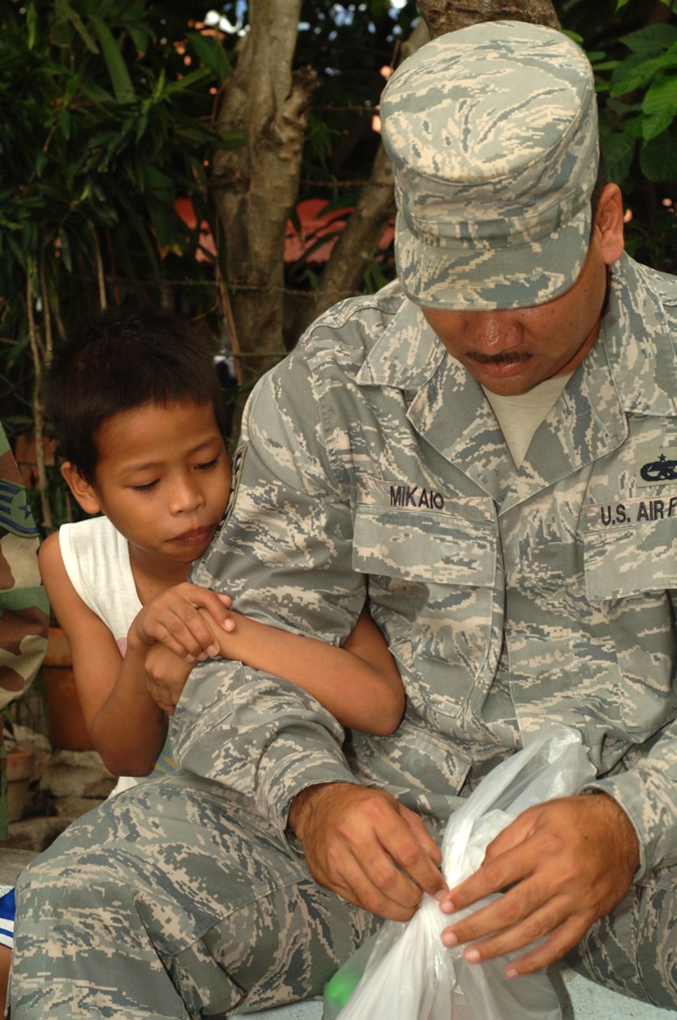 Tech. Sgt Jeffery Mikaio, from the 63rd Fighter Squadron, at Luke Air Force, Ariz., makes a new friend during a visit to a Filipino orphanage where more than twenty Airmen donated schools supplies, athletics equipment and toys here April 24-25. United States and the Republic of Philippines military forces are participating  in Balikatan  2009, an annual joint bilateral exercise designed to improve United States and the Republic of the Philippines combined planning, combat readiness and interoperability for a wide range of operations, from humanitarian assistance to peacekeeping missions throughout the region. (Marines Corps photo/ Petty Officer Second Class Robert Clowney)