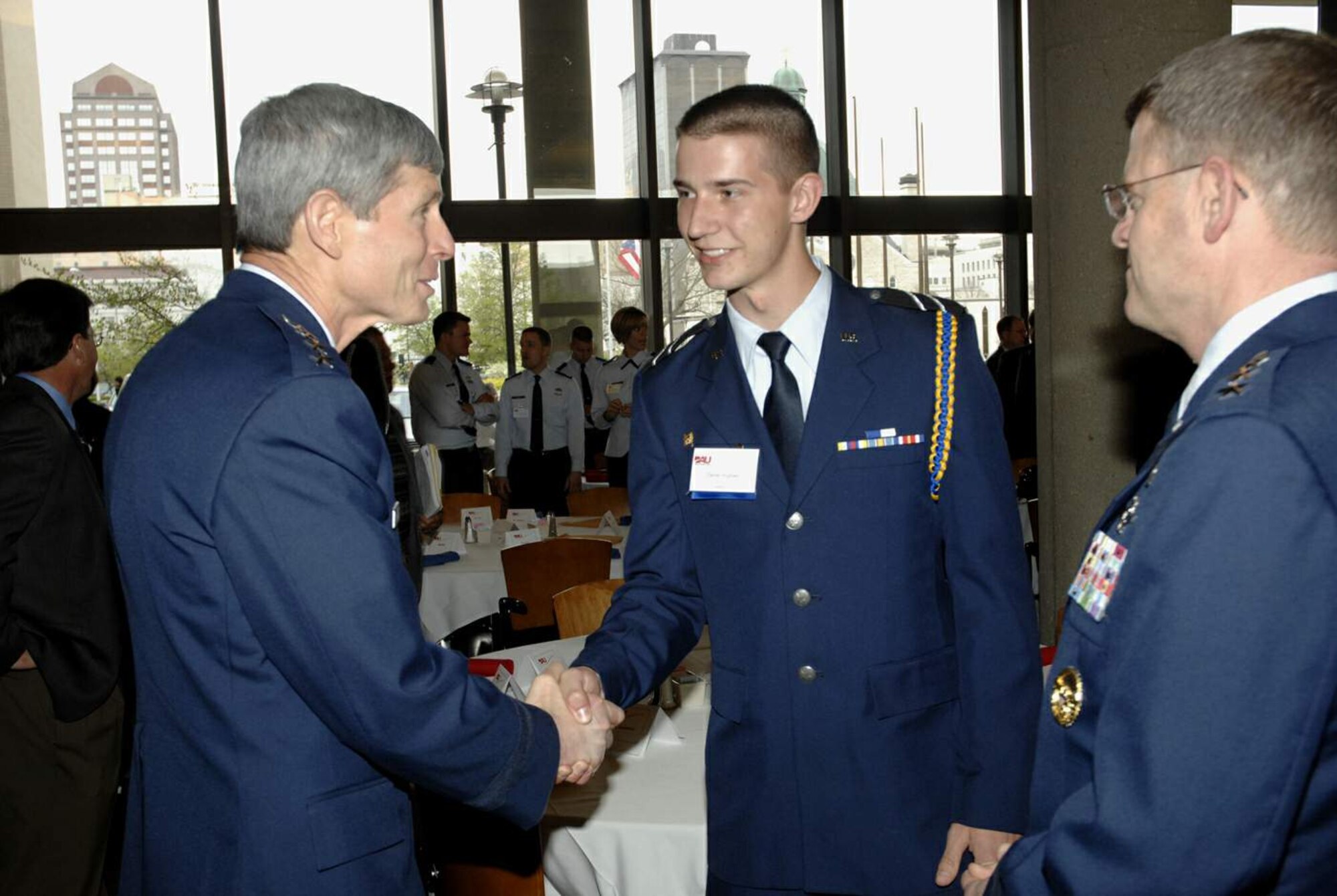 Gen. Norton Schwartz, Air Force chief of staff, congratulates University of Dayton Air Force ROTC Cadet 3rd Class Daniel Hughes on his decision to pursue a career as an Air Force officer, while Lt. Gen. Mark Shackelford, military deputy to the assistant secretary of the Air Force for acquisition, looks on. Generals Schwartz and Shackelford came to Dayton, Ohio, April 21 to congratulate and to challenge the Air Force acquisition workforce during DOD Acquisition Insight Days.  The event was organized by officials at Defense Acquisition University - Midwest Region and provided workshops, training and a forum for acquisition professionals to discuss ways to improve their processes.  (U.S. Air Force photo/Al Bright)