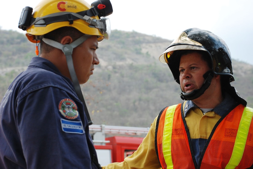 COMAYAGUA, Honduras - Sgt. Marlin Molina (right), a Honduran firefighter from Tegucigalpa, coordinates with a Salvadorian firefighter in response to a simulated explosion at La Farge Cement Factory here April 22.  Mr. Molina was the incident commander for the scenario, which was part of FA-HUM '09, a multinational disaster response exercise taking place in Honduras April 21-23.  (U.S. Air Force photo/Tech. Sgt. Rebecca Danét)