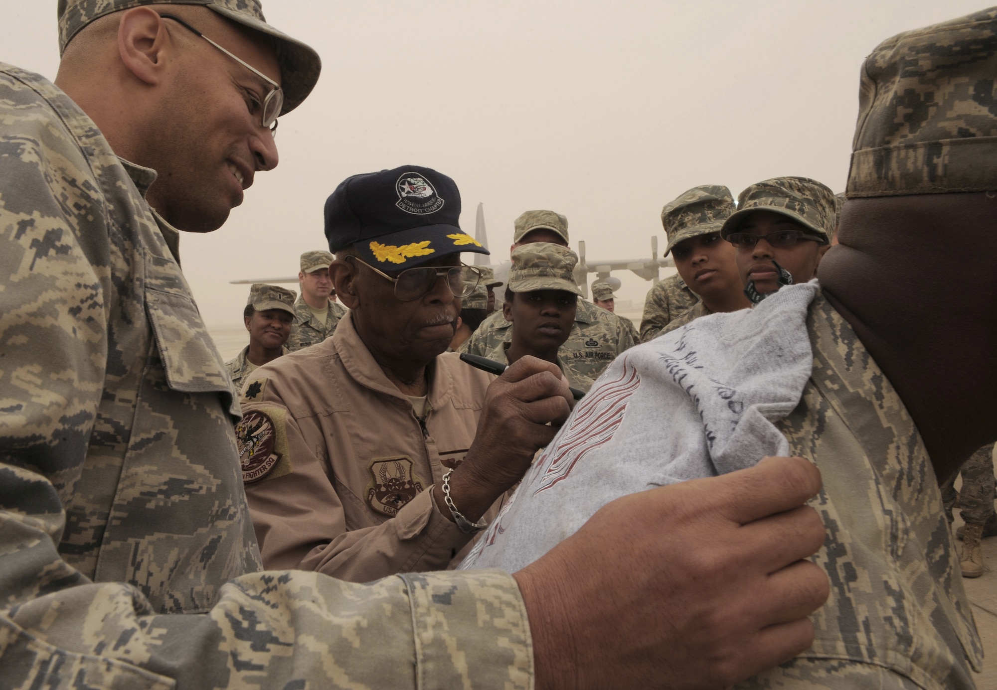 Retired Lt. Col. Alexander Jefferson, a Tuskegee Airman, signs a shirt and speaks with Airmen April 24 at Joint Base Balad, Iraq. Four Tuskegee Airmen met with Airmen here  assigned to the 332nd Air Expeditionary Wing during a three-day visit. (U.S. Air Force photo/Senior Airman Elizabeth Rissmiller)
