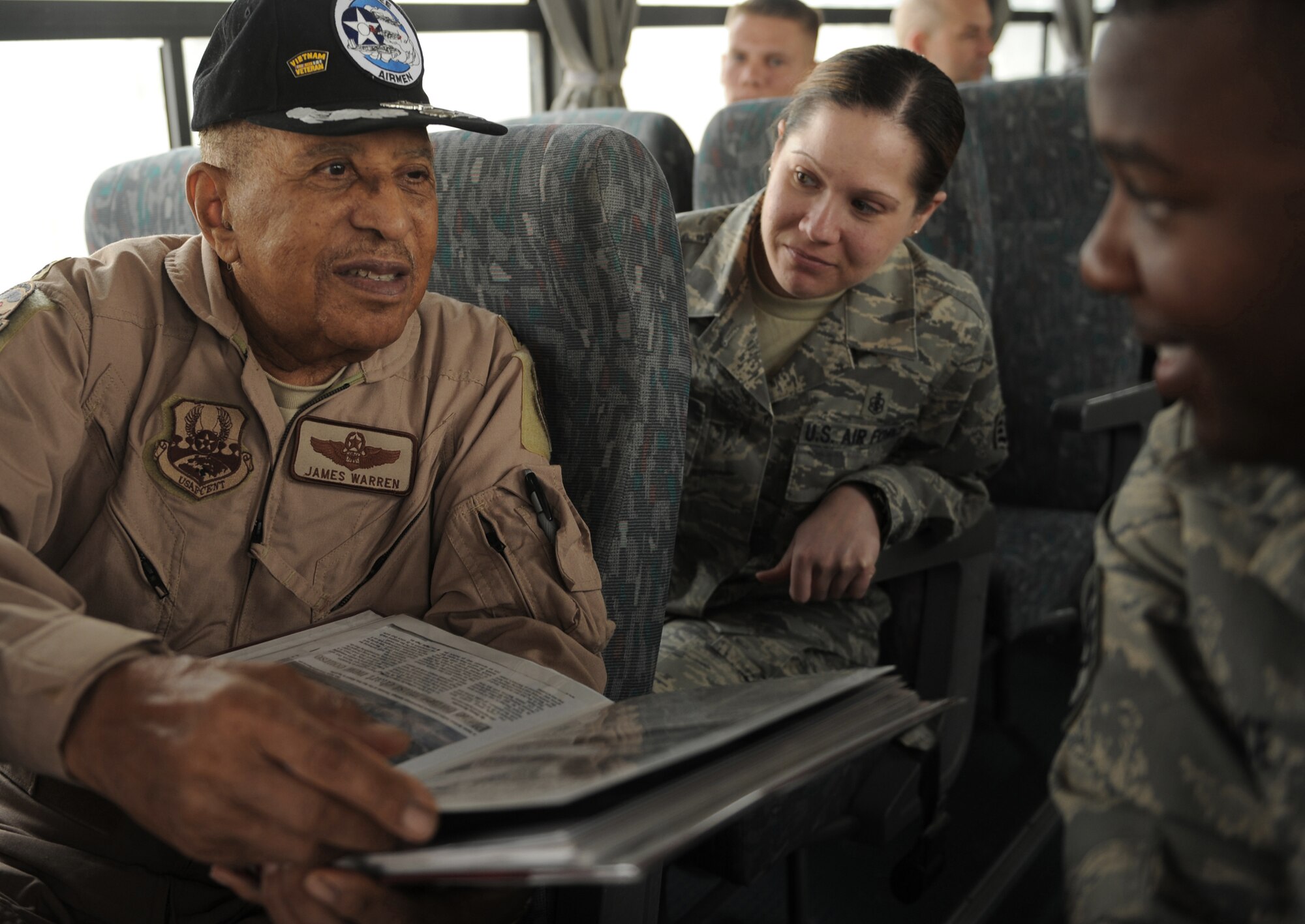 Retired Lt. Col. James Warren, a Tuskegee Airman, shares his scrapbook with Staff Sgts. Kelli Wietlisbach and Alphonso Price April 24 at Joint Base Balad, Iraq. Sergeant Wietlisbach is assigned to the 332nd Expeditionary Medical Support Squadron and Sergeant Price is assigned to the 332nd Expeditionary Security Forces Squadron. (U.S. Air Force photo/Senior Airman Elizabeth Rissmiller) 