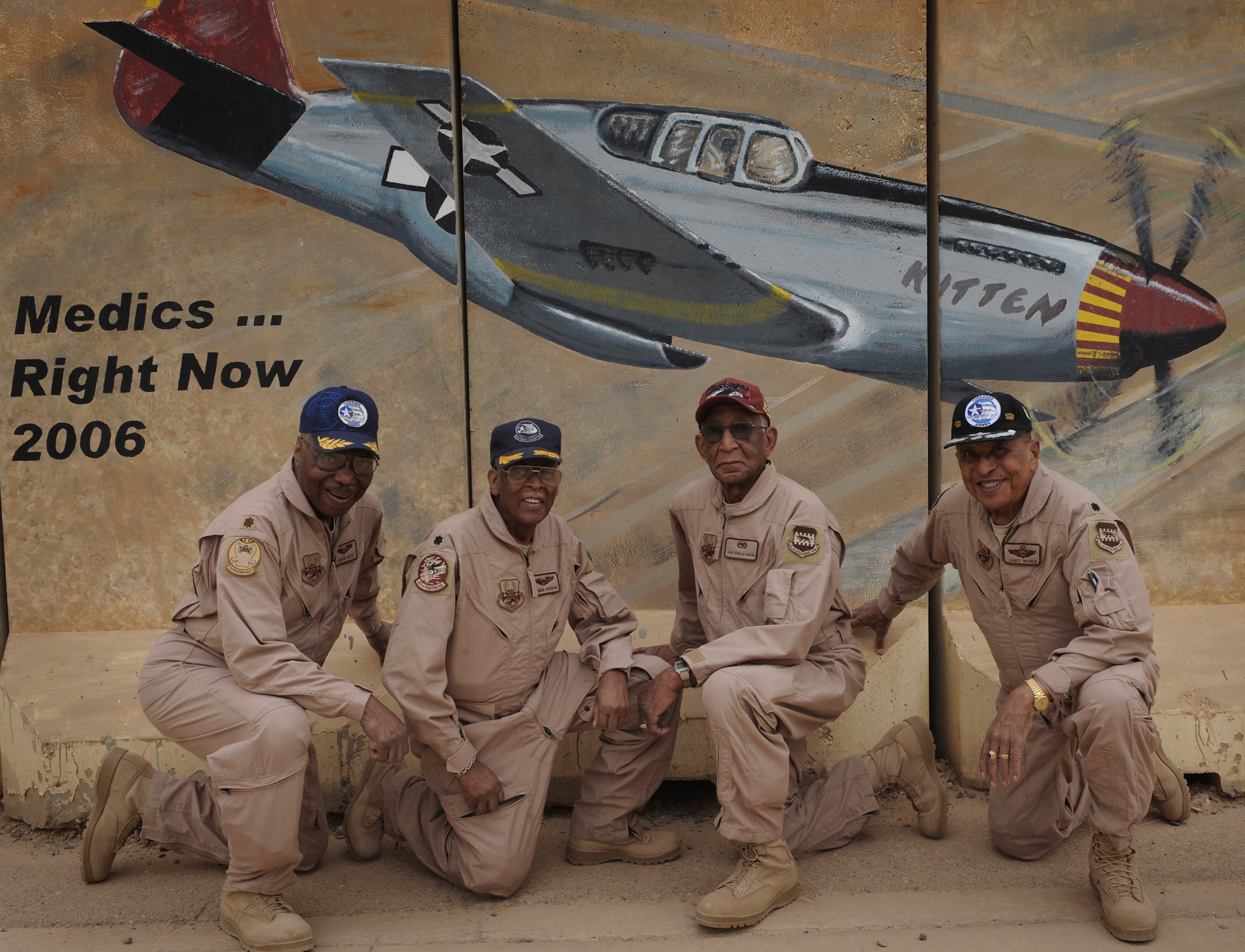 Tuskegee Airmen, retired Major George Boyd (from left), retired Lt. Col. Alexander Jefferson, former Staff Sgt. Phillip Broome and retired Lt. Col. James Warren, pose April 24 in front of barrier art here showing a "Red Tail" P-51 Mustang. The famed World War II pioneers met with Airmen assigned to the 332nd AEW. (U.S. Air Force photo/Senior Airman Elizabeth Rissmiller)