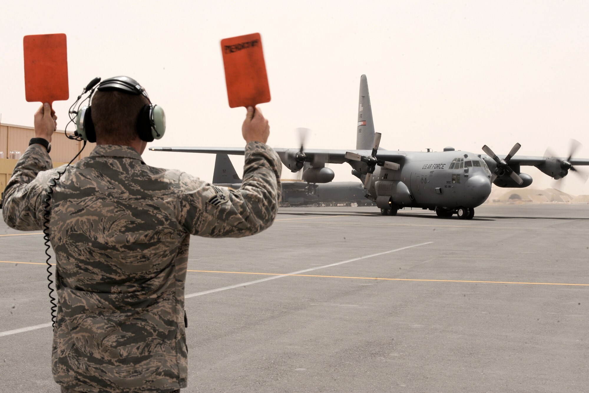 Senior Airman Jared Kamann marshals a C-130 Hercules into a parking spot April 20 at an air base in Southwest Asia. Airman Kamann is a 746th Aircraft Maintenance Unit crew chief. He is a native of Plymouth, Ohio, and is deployed from Pope Air Force Base, N.C. (U.S. Air Force photo/Staff Sgt. Joshua Garcia) 

