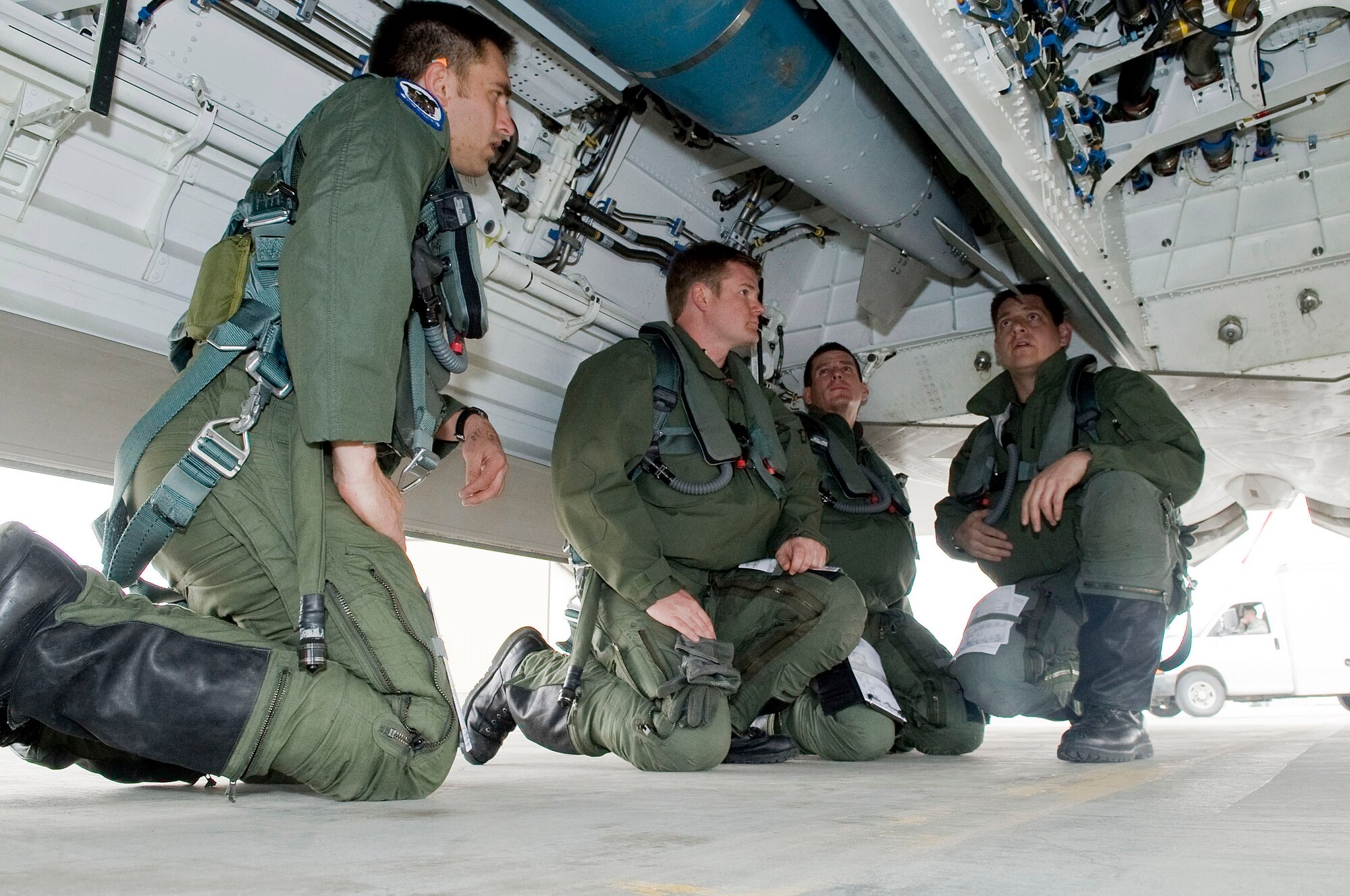 Pilots from the 525th Fighter Squadron discuss what to look for when a Joint Direct Attack Munition is loaded onto an F-22 Raptor April 14 at Elmendorf Air Force Base, Alaska. A 525th Fighter Squadron pilot dropped a JDAM that uses a guidance kit to direct the bomb onto a target. (U.S. Air Force photo/Senior Airman Jonathan Steffen) 
