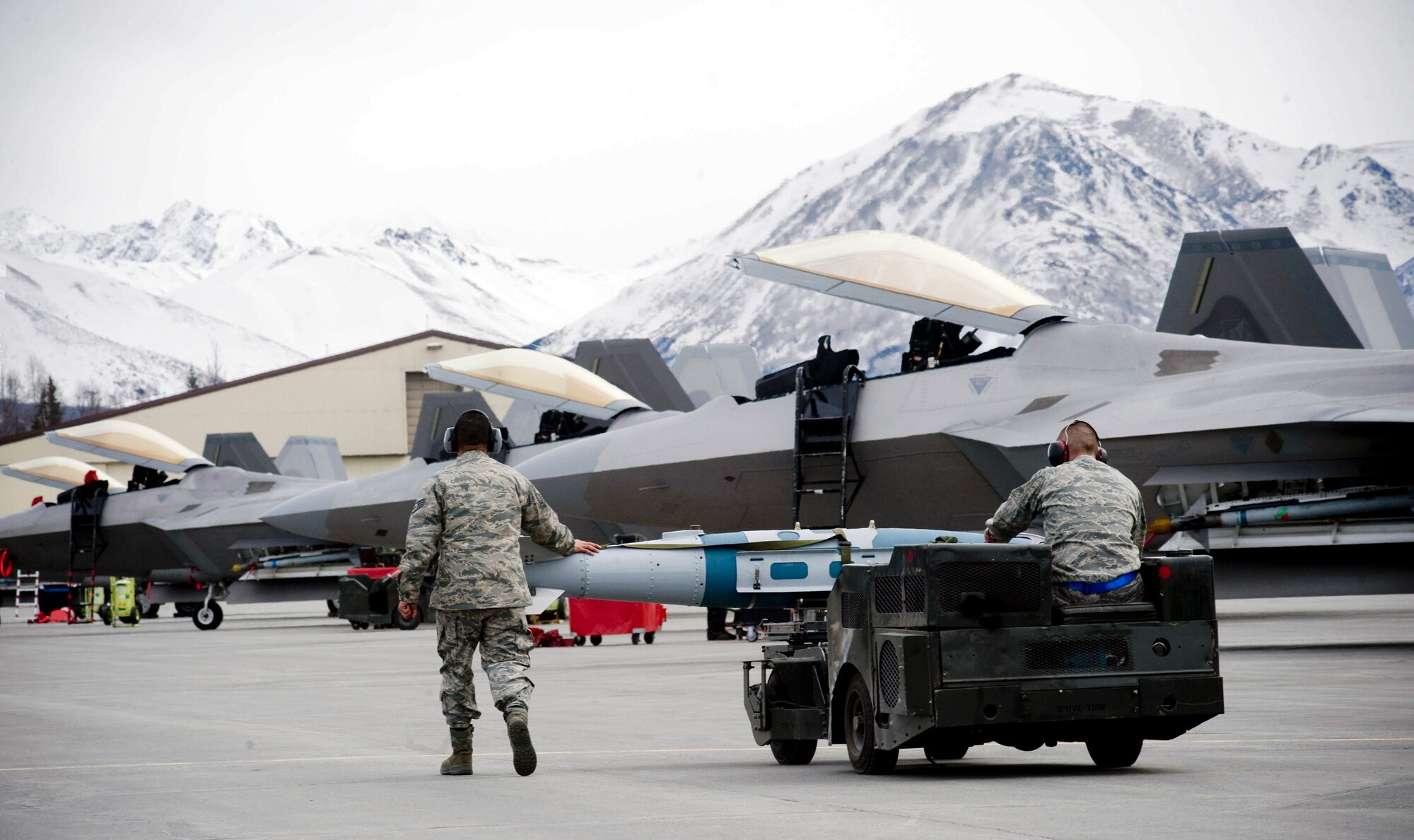 Staff Sgts. Michael Kalmar and Justin Akins move a Joint Direct Attack Munition along the flightline as F-22 Raptors await missions April 14 at Elmendorf Air Force Base, Alaska. Sergeants Kalmar and Akins are from the 525th Aircraft Maintenance Unit and ensured the JDAM dropped by the 525th Fighter Squadron is successful. (U.S. Air Force photo/Senior Airman Jonathan Steffen) 
