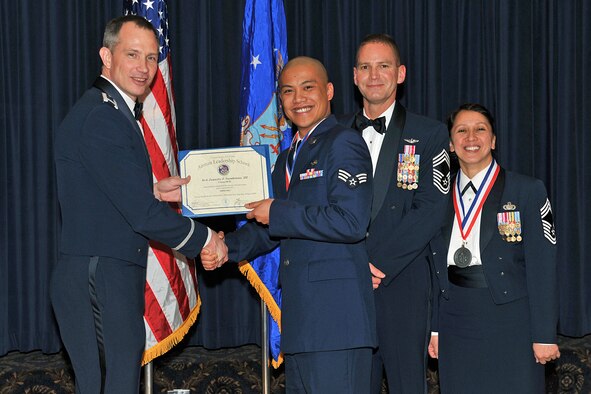 OFFUTT AIR FORCE BASE, Neb. - Col. Thomas Goffus, 55th Mission Support Group commander, Chief Master Sgt. James Pangle, 55th Operations Group superintendent and Chief Master Sgt. Paula Lopez, Air Force Weather Agency chief of knowledge operations management congratulate Senior Airman Juanito Sambrano III, 97th Intelligence Squadron, during Class 09-D's graduation from the James M. McCoy Airman Leadership School, at the Patriot Club April 2. Airman Sambrano is one of 45 ALS graduates of Class 09-D. "By completing ALS the graduates enhanced their leadership skills to guide the next generation of Airmen," Col. Goffus said. 