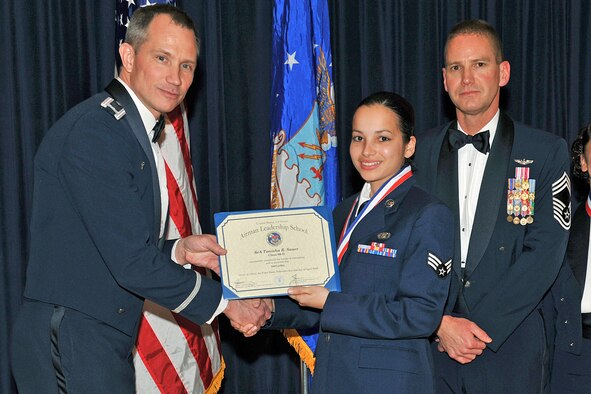 OFFUTT AIR FORCE BASE, Neb. - Col. Thomas Goffus, 55th Mission Support Group commander and Chief Master Sgt. James Pangle, 55th Operations Group superintendent congratulate Senior Airman Tanisha Sauer, 45th Reconnaissance Squadron, as she graduates from the James M. McCoy Airman Leadership School at the Patriot Club April 2. Airman Sauer is one of 45 ALS graduates of Class 09-D. "By completing ALS the graduates enhanced their leadership skills to guide the next generation of Airmen," Col. Goffus said. 