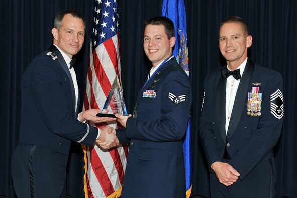 OFFUTT AIR FORCE BASE, Neb. - Col. Thomas Goffus, 55th Mission Support Group commander and Chief Master Sgt. James Prangle, 55th Operations Group superintendent present Senior Airman Matthew Russell, 97th Intelligence Squadron, with the distinguished graduate award during the graduation ceremony for Class 09-D of the James M. McCoy Airman Leadership School, at the Patriot Club April 2. Airman Russell is one of 45 ALS graduates of Class 09-D. "By completing ALS the graduates enhanced their leadership skills to guide the next generation of Airmen," Col. Goffus said. U.S. Air Force photo by Charles Haymond.