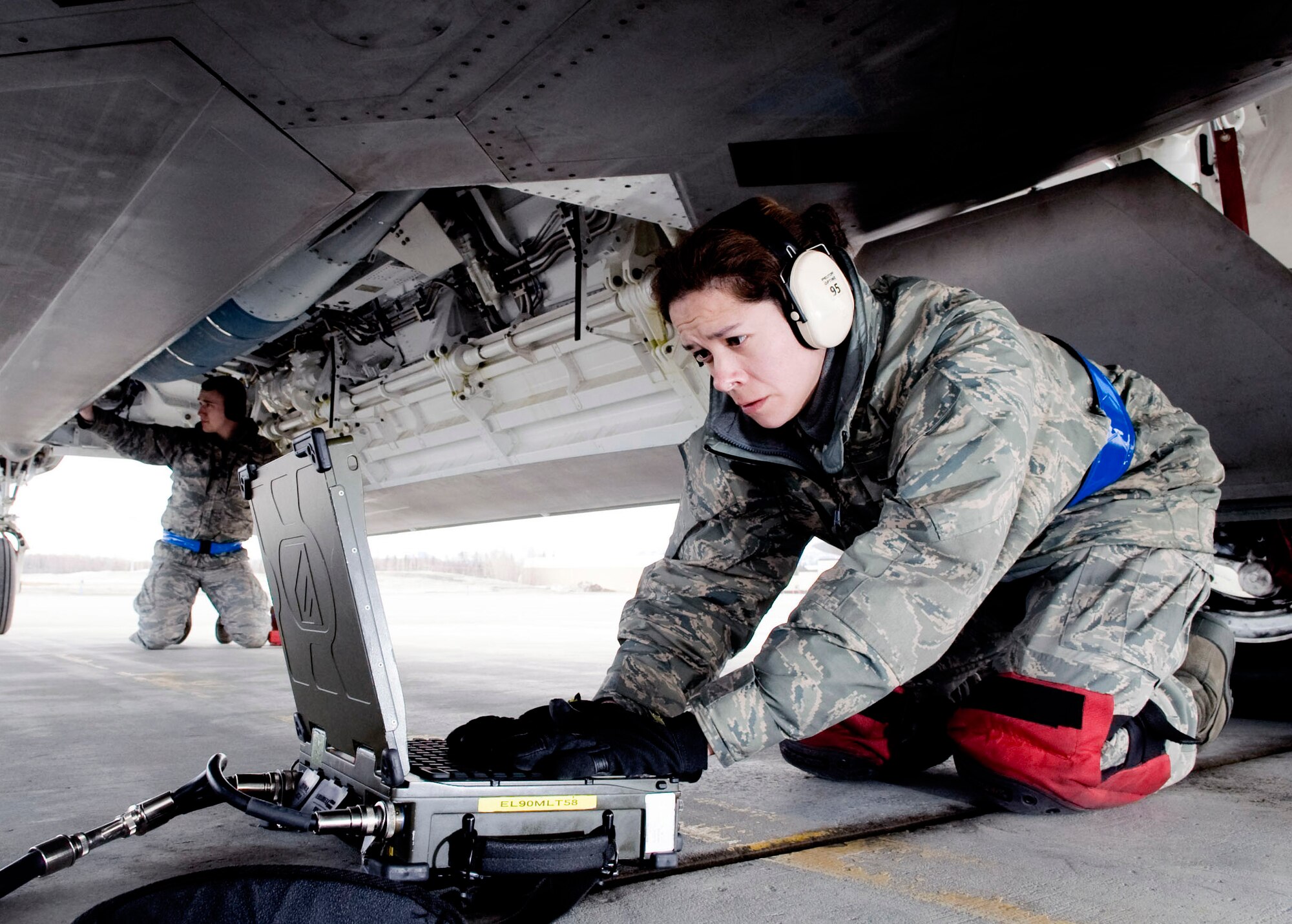Staff Sgt. Geneva Rumbaugh looks over her checklist after loading a Joint Direct Attack Munition onto an F-22 Raptor while Airman 1st Class Justin Baker inspects the JDAM April 14 at Elmendorf Air Force Base, Alaska. Sergeant Rumbaugh and Airman Baker, both from the 525th Aircraft Maintenance Unit, ensure the JDAM dropped by 525th Fighter Squadron is successful. (U.S. Air Force photo/Senior Airman Jonathan Steffen)