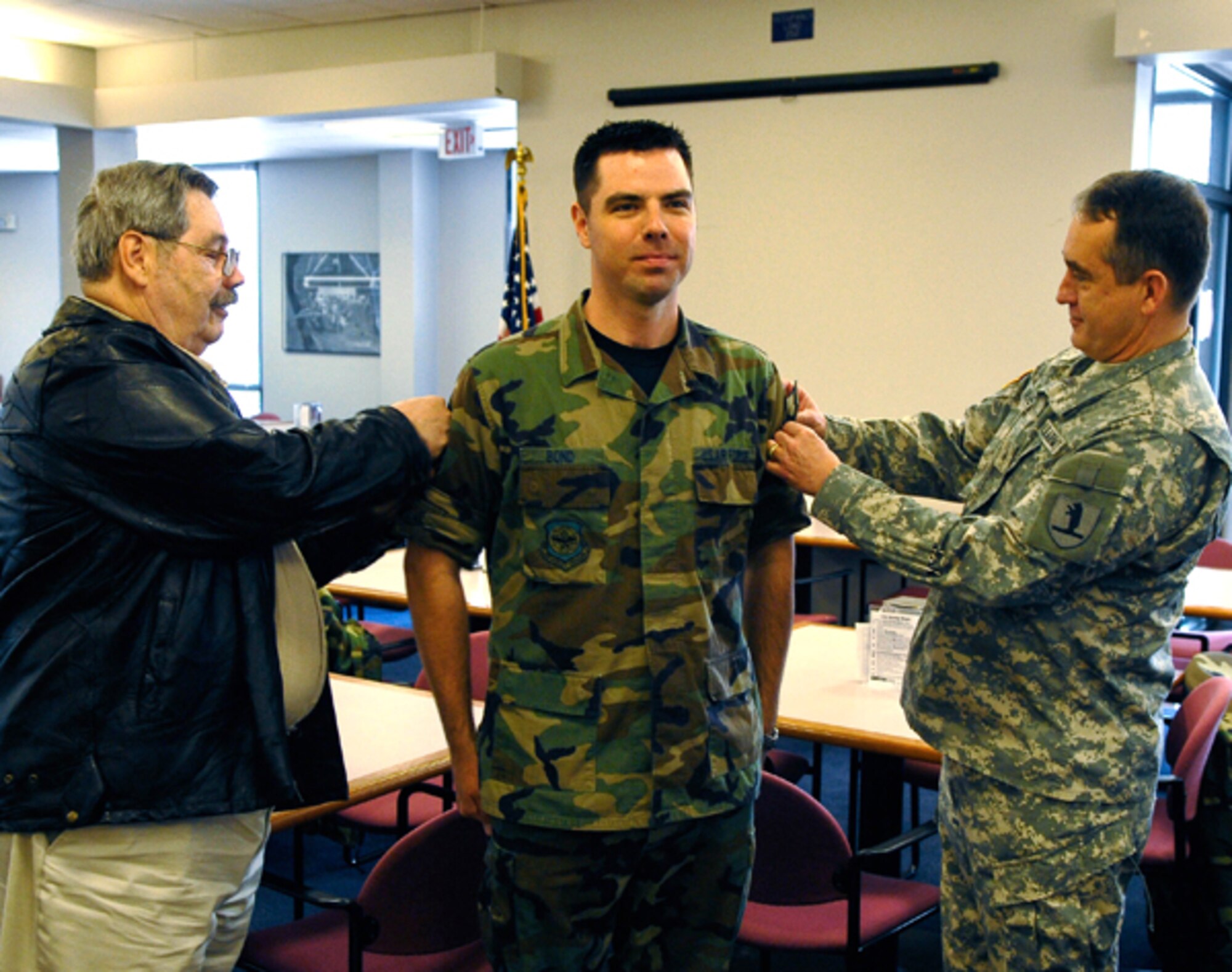 Tech. Sgt. Shannon Bond is awarded Master Sgt. stripes by Brigadier General Stephen Danner, Missouri adjutant general, and his father, George Bond, on 3 April, 2009. (U.S. Air Force photo by Master Sgt. Gregory Kunkle) (RELEASED) 