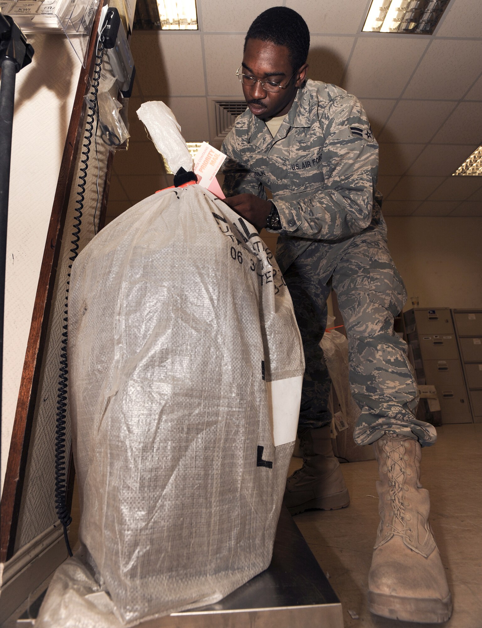 Airman 1st Class Cardell Polk weighs a package at the coalition compound post office April 20 at an air base in Southwest Asia. Airman Polk is native to New Orleans and is deployed from Pope Air Force Base, N.C. He is a postal clerk with the 379th Expeditionary Communication Squadron. (U.S. Air Force photo/Staff Sgt. Joshua Garcia) 
