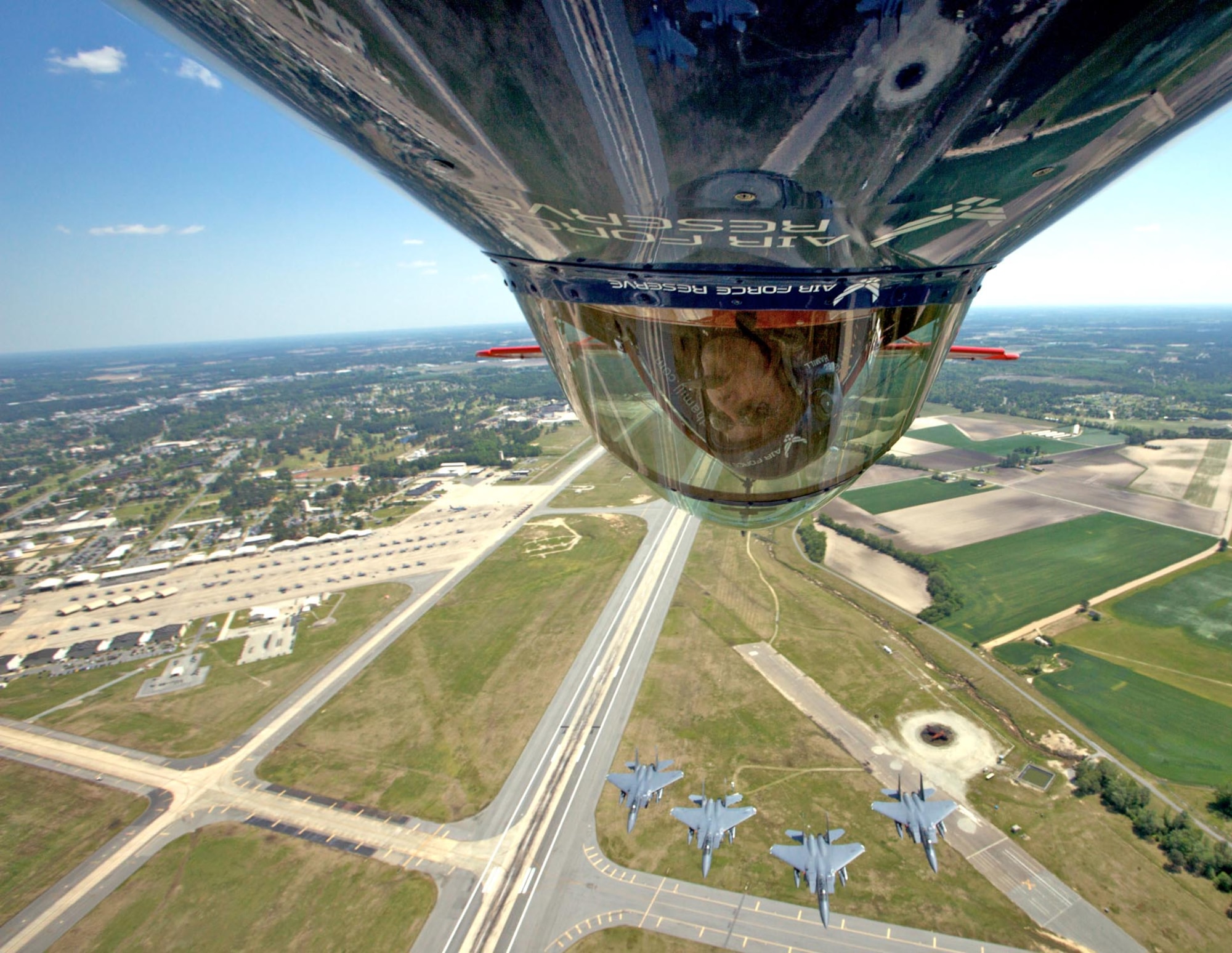 SEYMOUR JOHNSON AIR FORCE BASE, N.C. -- Pilot Ed Hamill turns his Air Force Reserve stunt plane upside down to get a better look at four F-15E Strike Eagles approaching from the rear. Hamill was a part of the two-day air show here on April 25-26 that attracted more than 100,000 spectators.