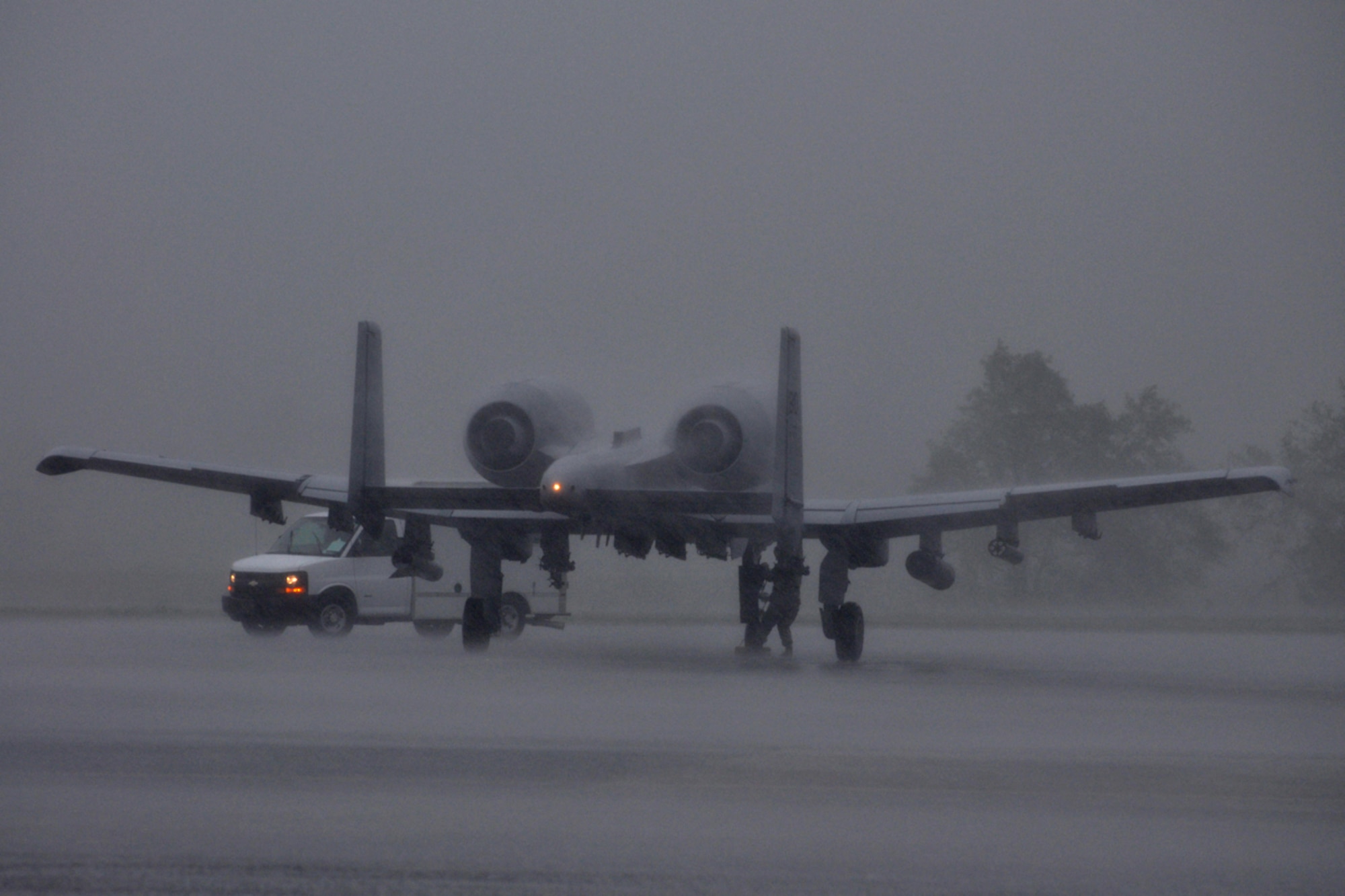 An Airman from the 917th Wing at Barksdale Air Force Base, La., chocks an A-10 Thunderbolt in a torrential downpour at Savannah Combat Readiness Training Center in Savannah, Ga., April 2, 2009. For his own safety and the protection of the aircraft’s cockpit, the pilot was forced to stay in the jet until the storm passed. (US Air Force photo/Tech. Sgt. Jeff Walston)