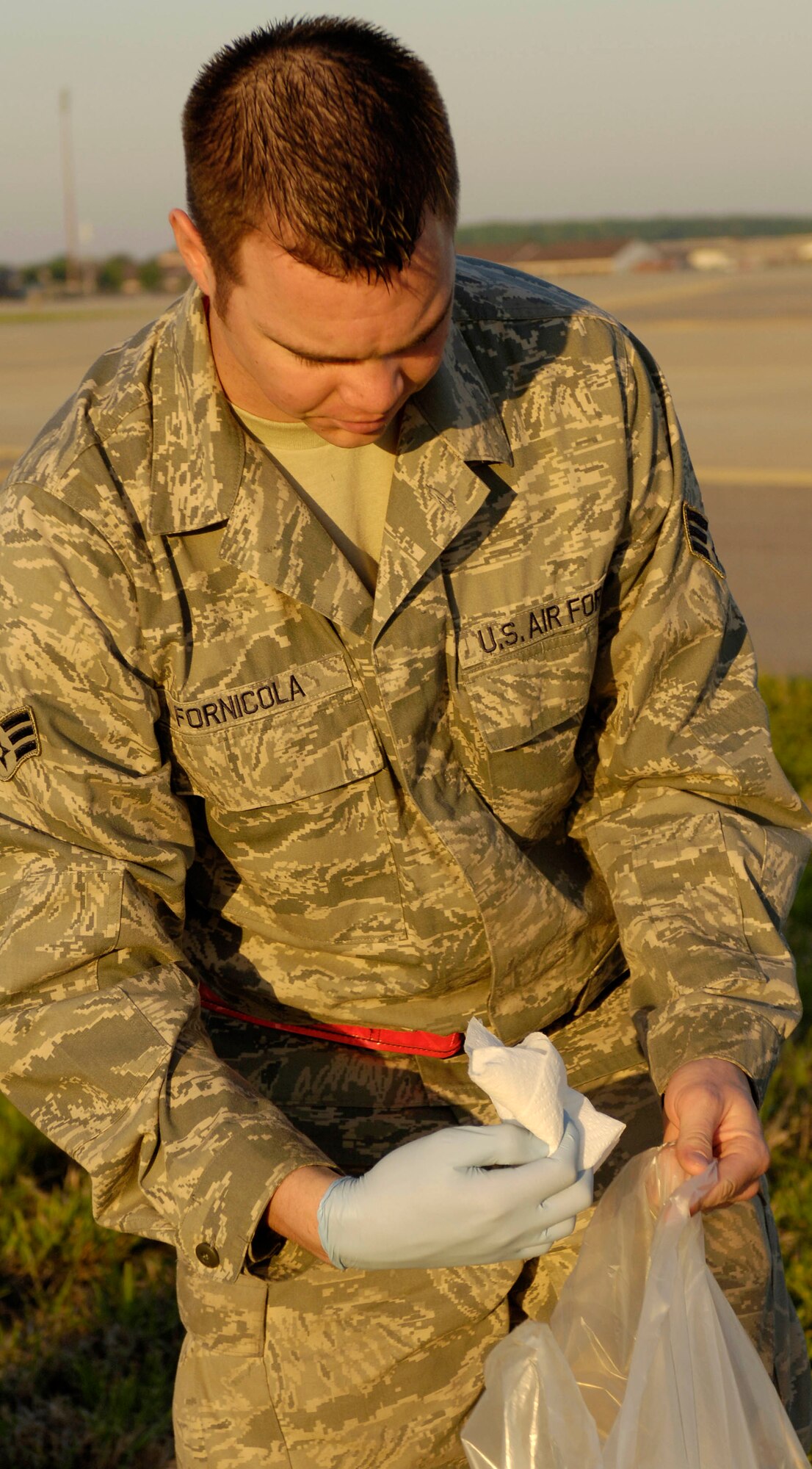 LANGLEY AIR FORCE BASE, Va. -- Senior Airman Anthony Fornicola, 71st Aircraft Maintenance Squadron, picks up foreign object debris on flightline April 27. The post-air show FOD walk was used to eliminate debris left behind from the fun filled weekend. (U.S. Air Force photo/Airman Rebecca Montez)