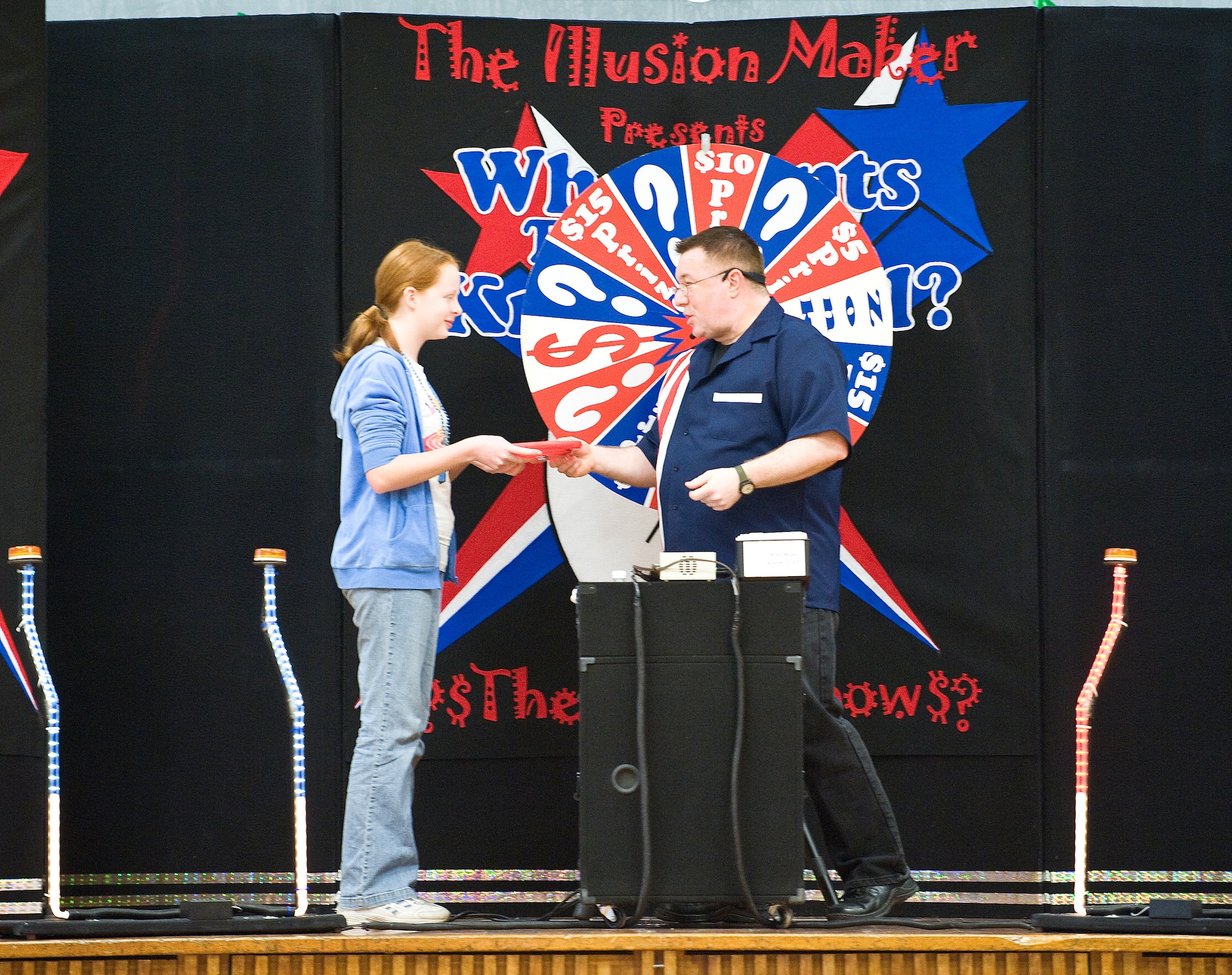 David Boslough (right), host of “Who Wants to be a Know it All,” an environmental-themed game show, hands 7th grader Ginny Hartung her prize for winning the show at Air Base Middle School on Dover Air Force Base April 24. (U.S. Air Force photo/ Tom Randle)