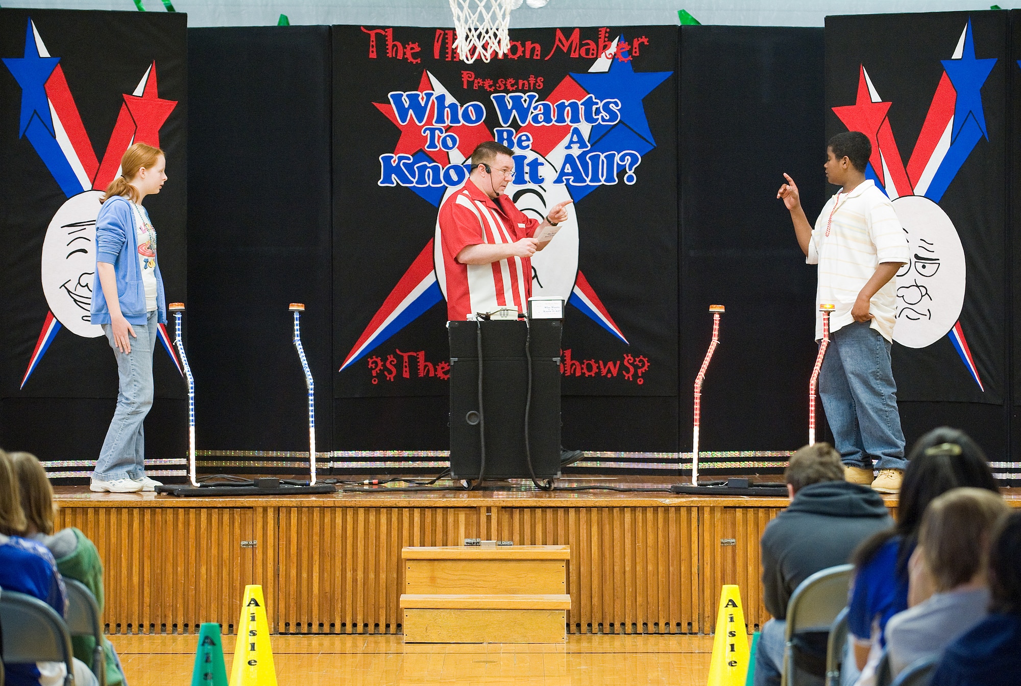 Ginny Hartung, a 7th grader at Air Base Middle School on Dover Air Force Base, waits for a response as the Illusion Maker, David Boslough, asks her opponent 7th grader Anthony Elliot an environmental-related question. Though Ms. Hartung won the match in the final round, all students in attendance were taught three important aspects of keeping the Earth green: reuse, reduce and recycle. (U.S. Air Force photo/ Tom Randle) 