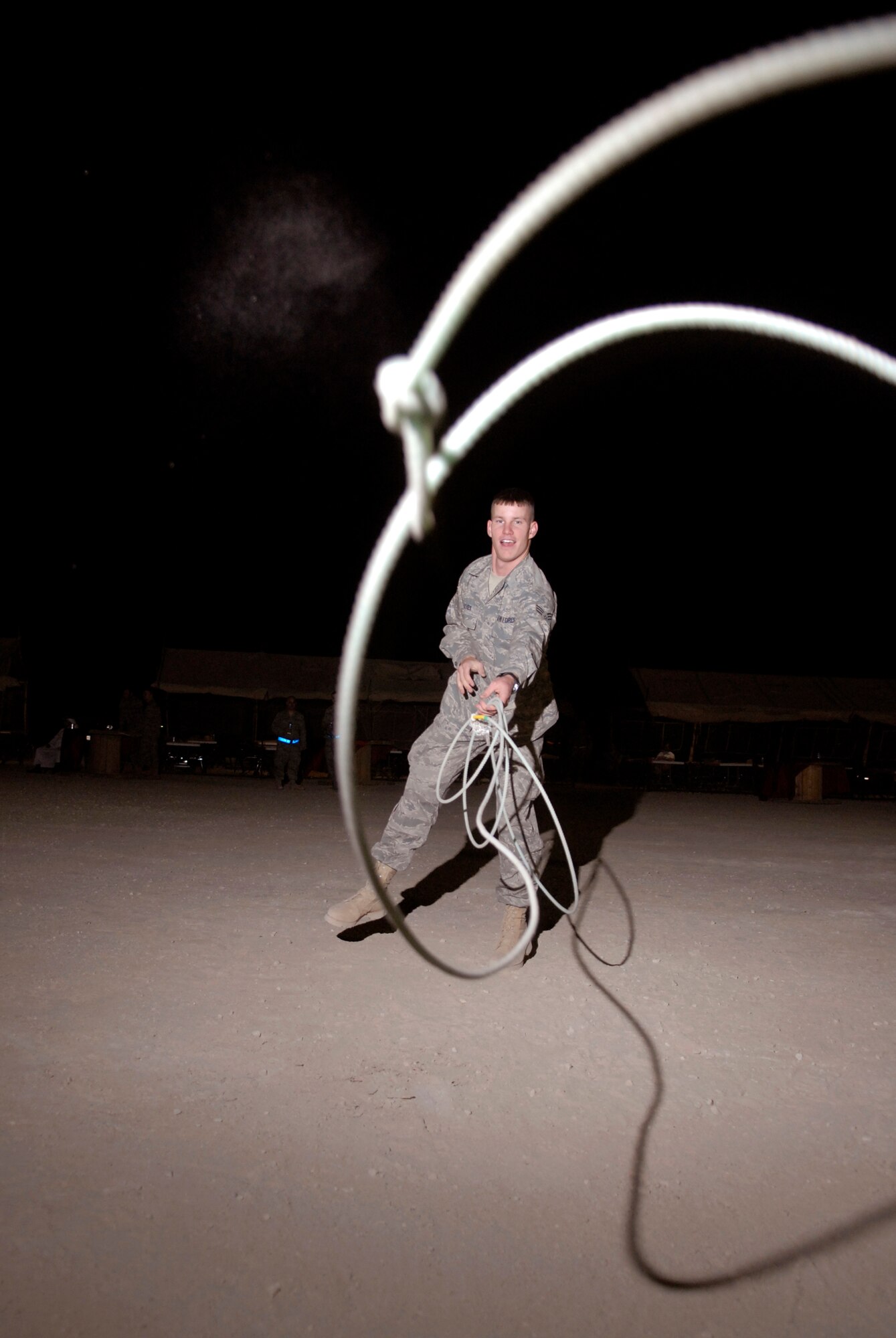 Senior Airman George Reves, from the 379th Expeditionary Maintenance Squadron, demonstrates throwing a lasso during the Texas Style barbeque cultural event hosted by the 379th Air Expeditionary Wing, April 23, 2009, at an undisclosed location in Southwest Asia.  During the event coalition members and host nation guests participated in throwing horseshoes and a lasso, riding a mock mechanical bull, and eating Texas style food, to share some American culture.  Airman Reves hails from Follett, Texas and is deployed from Dyess Air Force Base, Texas, in support of Operations Iraqi and Enduring Freedom and Combined Joint Task Force - Horn of Africa.  (U.S. Air Force photo/Senior Airman Andrew Satran/released)