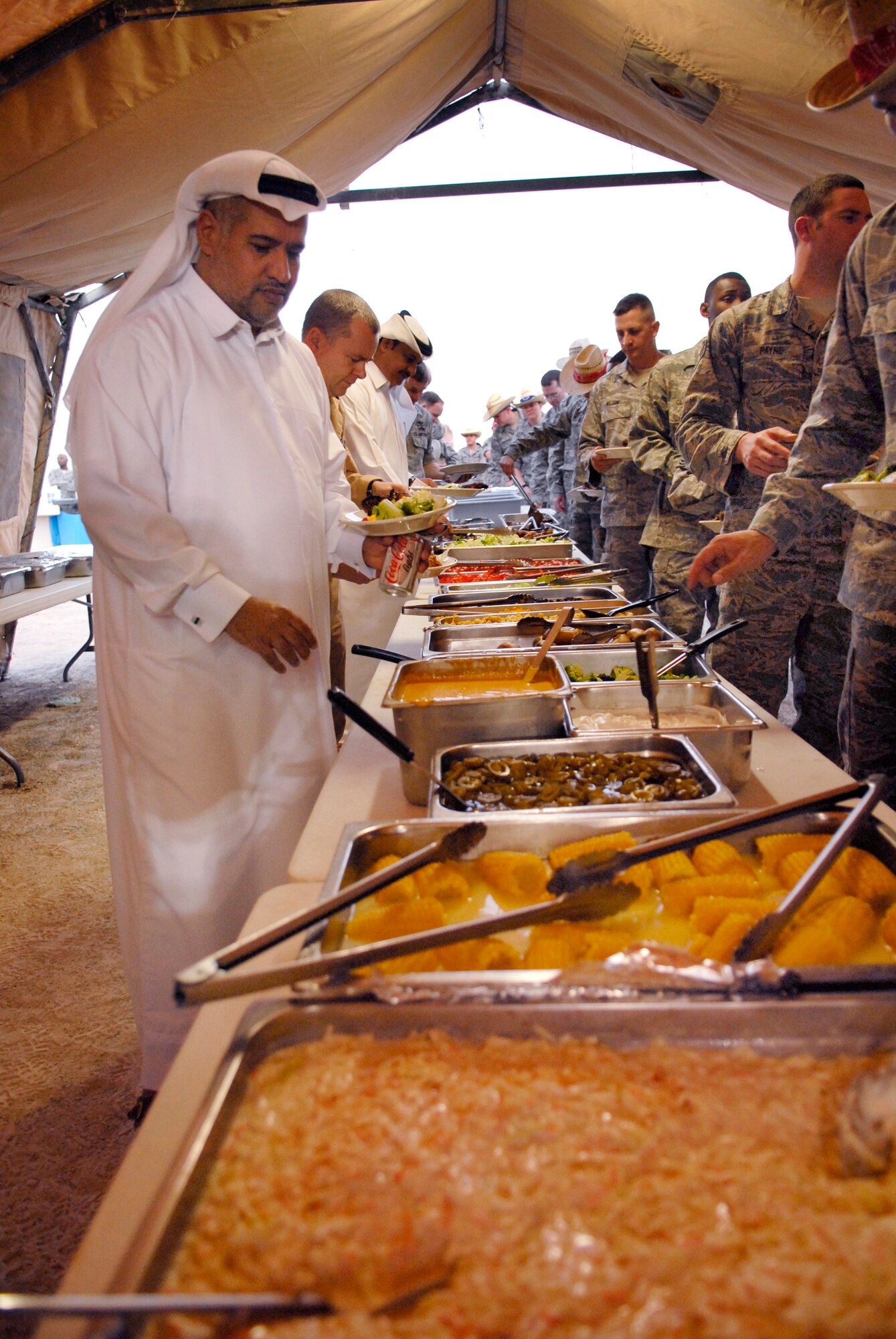 Brig. Gen. Abdullah Jassim Al Muraikhi samples some American cuisine during the Texas Style barbeque cultural event hosted by the 379th Air Expeditionary Wing, April 23, 2009, at an undisclosed location in Southwest Asia.  During the event coalition members and host nation guests participated in throwing horseshoes and a lasso, riding a mock mechanical bull, and eating Texas style food, to share some American culture.  The servicemembers who participated in this event are deployed in support of Operations Iraqi and Enduring Freedom and Combined Joint Task Force - Horn of Africa.  (U.S. Air Force photo/Senior Airman Andrew Satran/released) 
