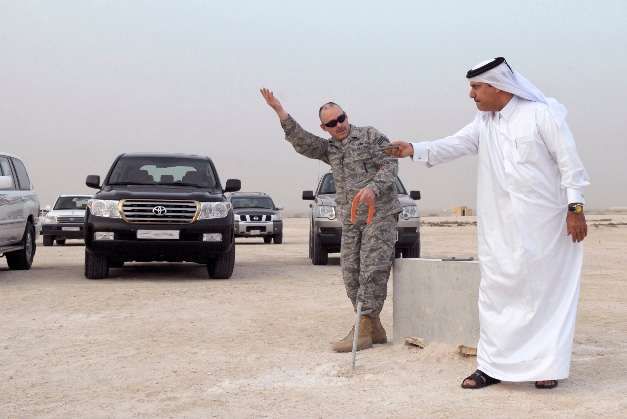 Chief Master Sgt. Pat Brown, 379th Expeditionary Maintenance Squadron Chief Enlisted Manager, shows the proper technique for throwing a horseshoe to Lt. Col. Abdul Hameed during the Texas Style barbeque cultural event hosted by the 379th Air Expeditionary Wing, April 23, 2009, at an undisclosed location in Southwest Asia.  During the event coalition members and host nation guests participated in throwing horseshoes and a lasso, riding a mock mechanical bull, and eating Texas style food, to share some American culture.  Chief Master Sgt. Bowen hails from Glassco, Mont. and is deployed from Tyndall Air Force Base, Fla. in support of Operations Iraqi and Enduring Freedom and Combined Joint Task Force - Horn of Africa.  (U.S. Air Force photo/Senior Airman Andrew Satran/released)