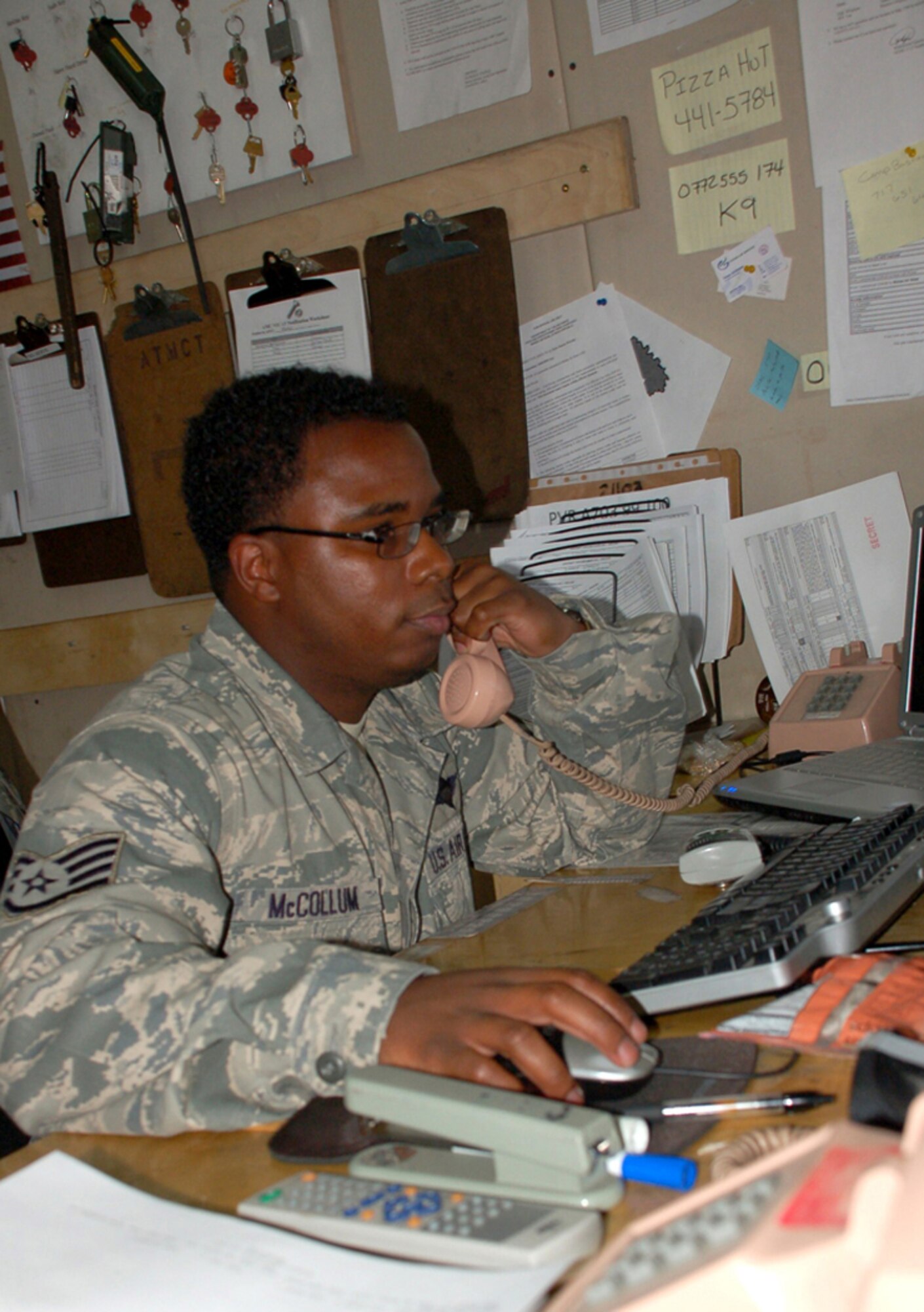 Staff Sgt. Markis McCollum coordinates an inbound aircraft delivering cargo to Manas Air Base, Kyrgyzstan, April 18. For the past five weeks, the 376th Expeditionary Logistics Readiness Squadron's Air Terminal Operations Center has been supporting three C-17 aircrews from Pacific Air Forces who have been flying three flights nearly every day in order to deliver needed supplies to support the buildup of various bases supporting Operation Enduring Freedom. As the port information controller, Sergeant McCollum runs the nerve center of 376th ELRS ATOC by keeping logisticians posted on when aircraft are coming and going. Sergeant McCollum is deployed from the 727nd Air Mobility Squadron at RAF Mildenhall, England. (U.S. Air Force photo/Tech. Sgt. Phyllis Hanson)