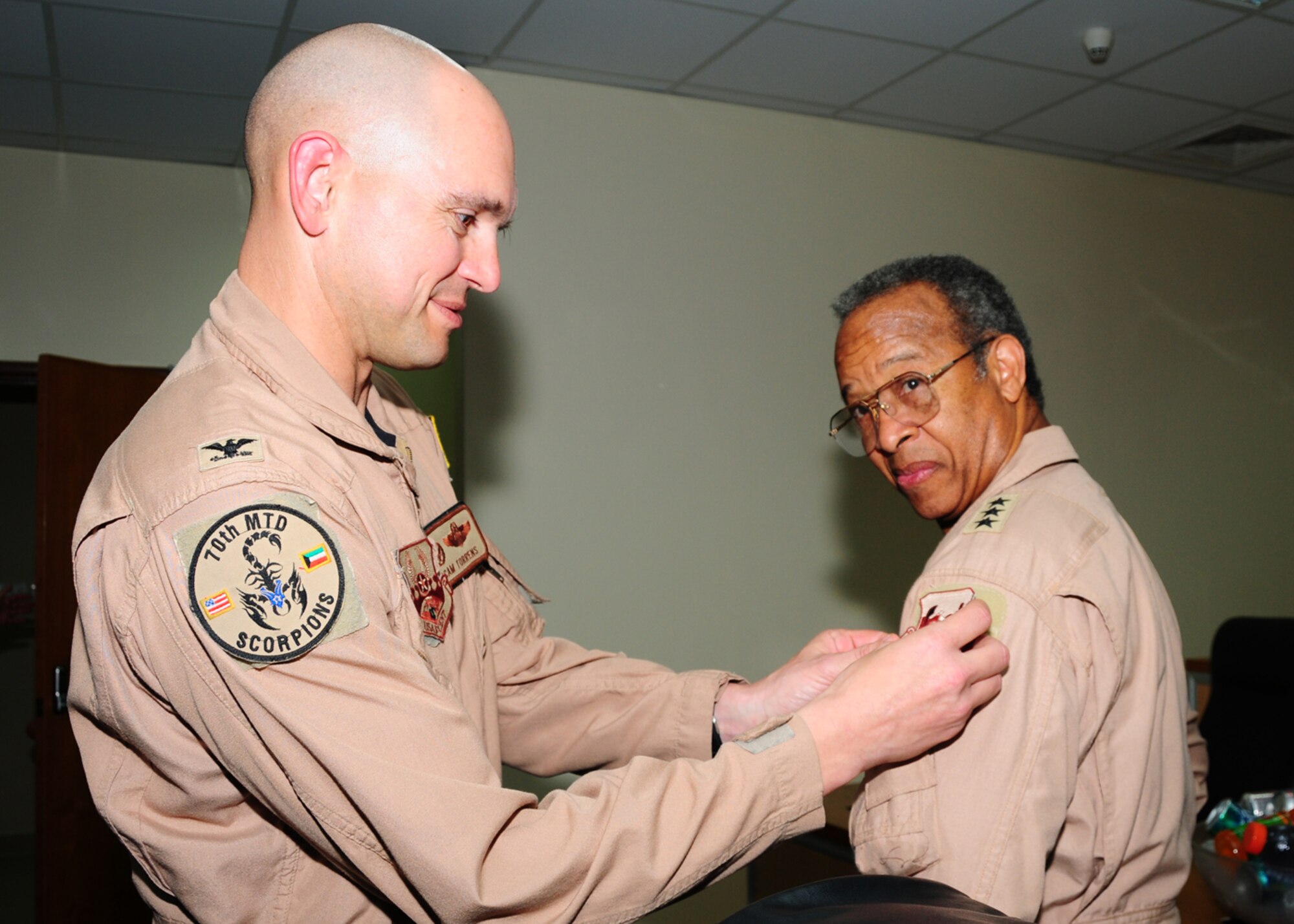 SOUTHWEST ASIA -- Col. Cameron Torrens presents retired Lt. General Russell Davis, president of the national chapter of Tuskegee Airmen, Inc., a 386th Air Expeditionary Wing patch to show his appreciation of their hard work and for visiting the Airmen of the 386th. Each group commander presented one of the four visiting Tuskegee Airmen with a patch during a mission briefing. (U.S. Air Force photo/ Senior Airman Courtney Richardson)