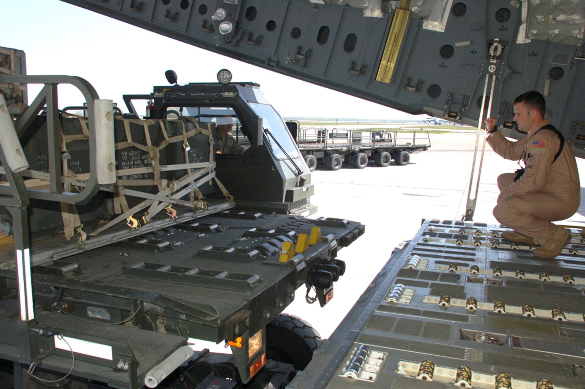 Staff Sgt. Ryan Stark, right, guides a 25K Halvorsen loader into position as Airman 1st Class Tyler Johnson delivers cargo pallets for upload onto a C-17 Globemaster III going to Afghanistan from Manas Air Base, Kyrgyzstan, April 18. For the past five weeks, the 376th Expeditionary Logistics Readiness Squadron the Air Terminal Operations Center has been supporting three C-17 aircrews deployed from Pacific Air Forces who have been flying three flights nearly every day in order to deliver needed supplies to support the buildup of various bases for Operation Enduring Freedom. Sergeant Stark is a loadmaster deployed with the 535th Airlift Squadron at Hickam Air Force Base, Hawaii. Airman Johnson is assigned 376th ELRS and is deployed from the 60th Aerial Port Squadron at Travis Air Force Base, Calif. (U.S. Air Force photo/Tech. Sgt. Phyllis Hanson)
