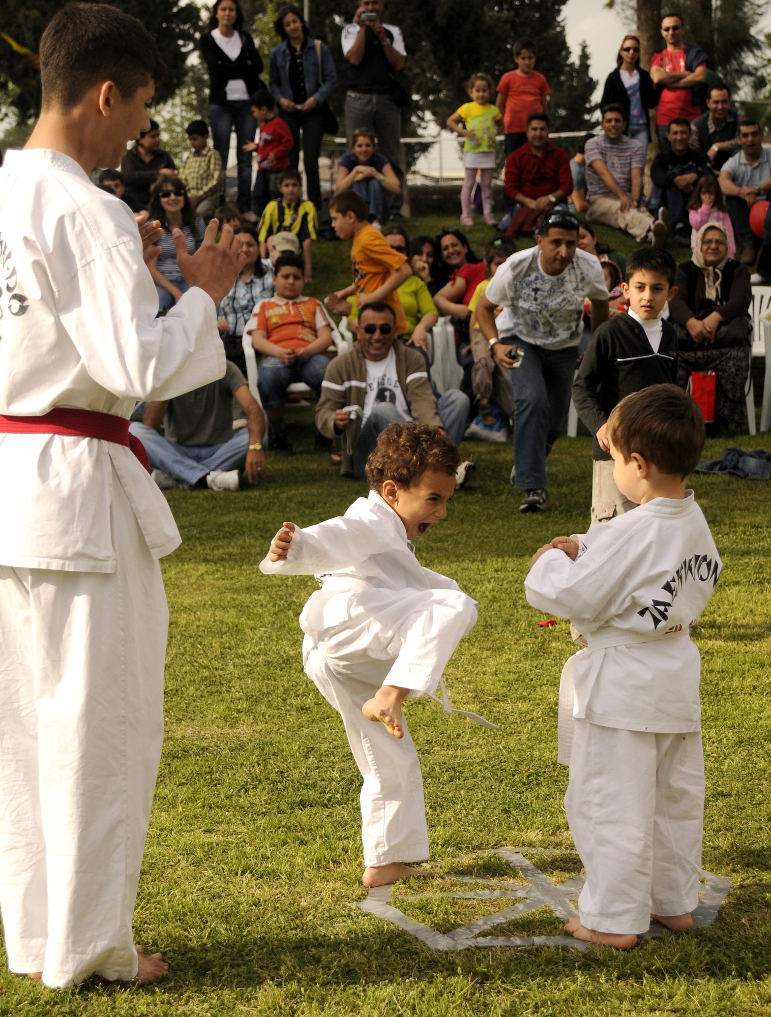 A young Turkish Tae Kwon Do instructor stands by as beginning students perform moves against the other during a demonstration at the Turkish Children’s Festival at Arkadas Park at Incirlik Air Base, Turkey. The day was celebrated with traditional folk dances, the Tae Kwon Do show, races and local Turkish food.  More than 200 people were in attendance to the festival, a mix of American and Turkish families from the base.  (U.S. Air Force photo/Amber Russell)