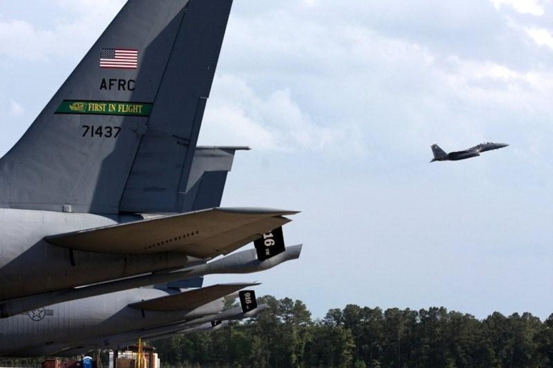 SEYMOUR JOHNSON AIR FORCE BASE, N.C. -- An F-15E Strike Eagle takes off past a row of KC-135R Stratotankers prior to the Wings Over Wayne Air Show. The week before the air show was dedicated to welcoming various aerial teams from around the country, practicing for the show and flying media aboard an Air Force Reserve tanker to see a mid-air refueling with the Strike Eagles. (Photo courtesy of Mr. Gray Whitley)