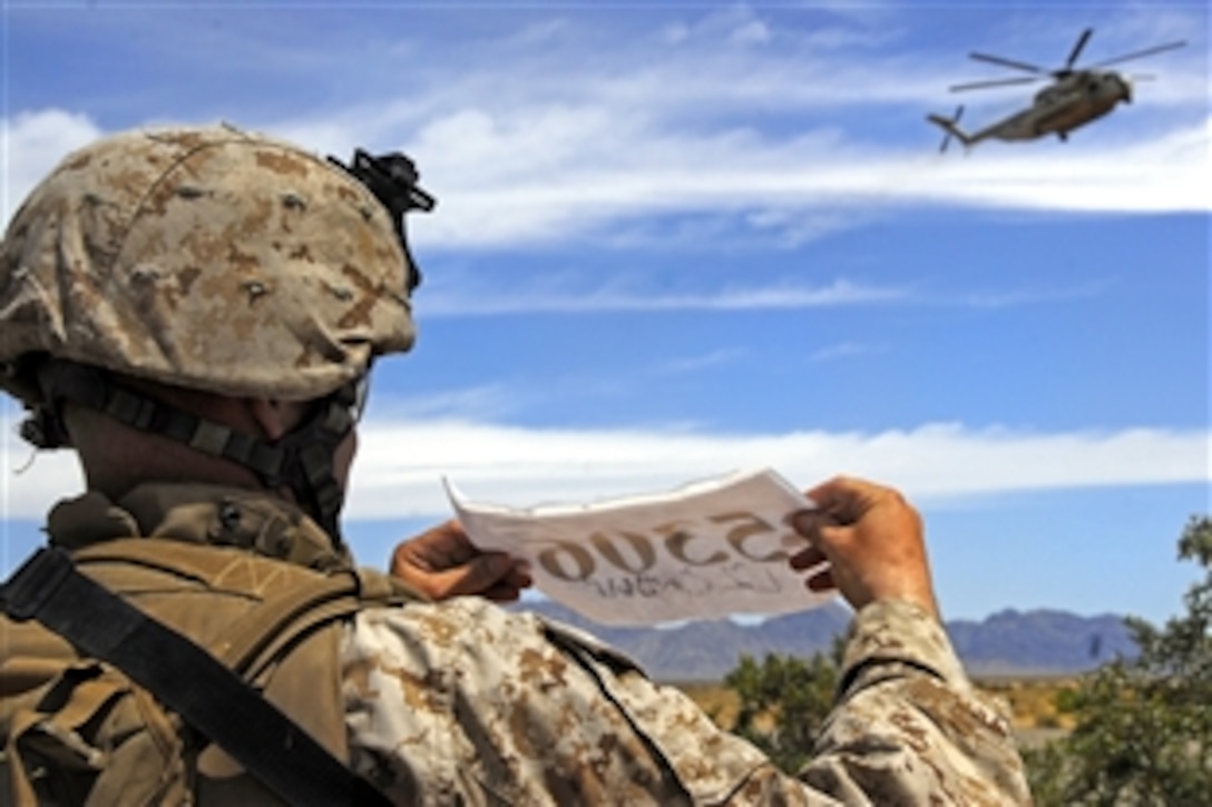 U.S. Sgt. Jared Leiss shows his squad's number for the MV-22 Osprey pilot who picked up the Marines at during an air assault exercise in a training area east of Marine Corps Air Station Yuma, Ariz., April 13, 2009. Leiss a squad leader assigned to the 3rd Battalion, 9th Marine Regiment.