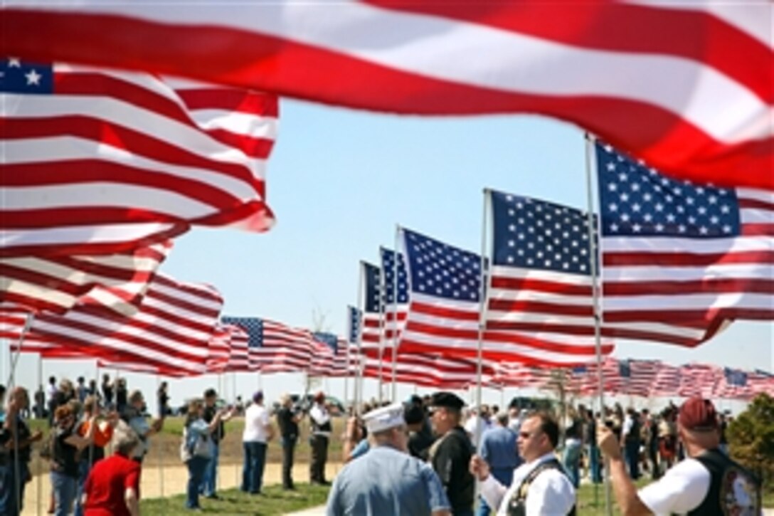 More than 500 veterans who escorted the unclaimed remains of seven Iowa veterans to their final resting place line the procession route with American flags after providing a motorcycle escort to the Iowa Veterans Cemetery, Van Meter, Iowa, April 24, 2009. The ceremony coincided with Des Moines Navy Week, one of 22 Navy Weeks planned across America in 2009.