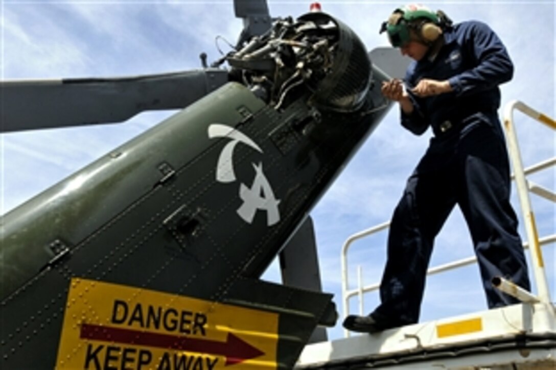 U.S. Navy Seaman Christopher Cockroft installs a tail gear box cover on an SH-60F Sea Hawk helicopter aboard the amphibious command ship USS Blue Ridge in the Pacific Ocean, April 24, 2009. Cockroft is an aviation machinist's mate.