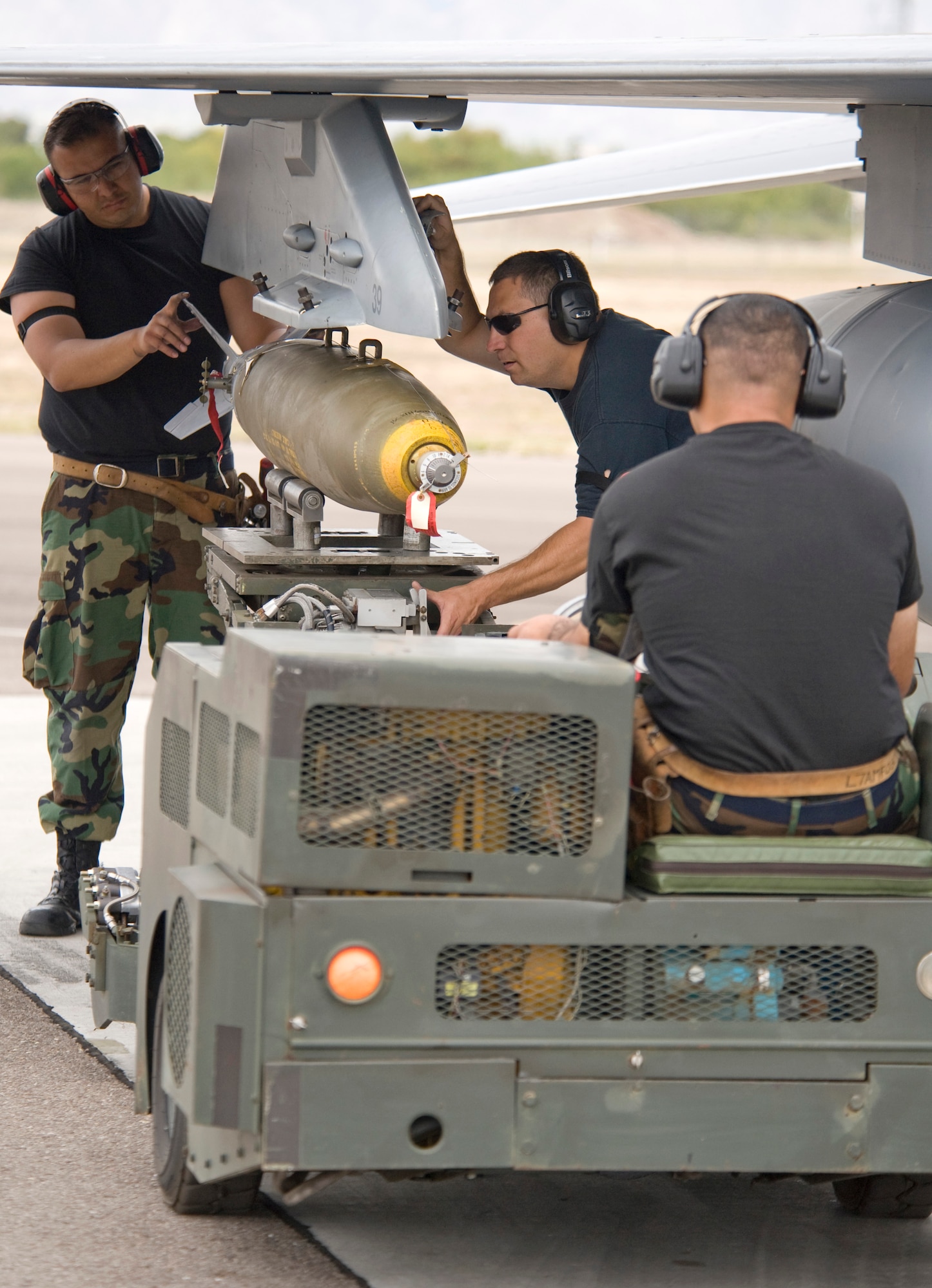 Staff Sgt. William Sanchez (left to right), Tech. Sgt Alan Colombo and Staff Sgt. Jaime Alonzo load a live MK-82 500-pound bomb onto an F-16 Fighting Falcon April 27 at Davis-Monthan Air Force Base, Ariz. The Guard members are participating in Exercise Coronet Cactus. The three Airmen are weapons loaders from the Texas Air National Guard’s 149th Fighter Wing. (U.S. Air Force photo/Master Sgt. Jack Braden)