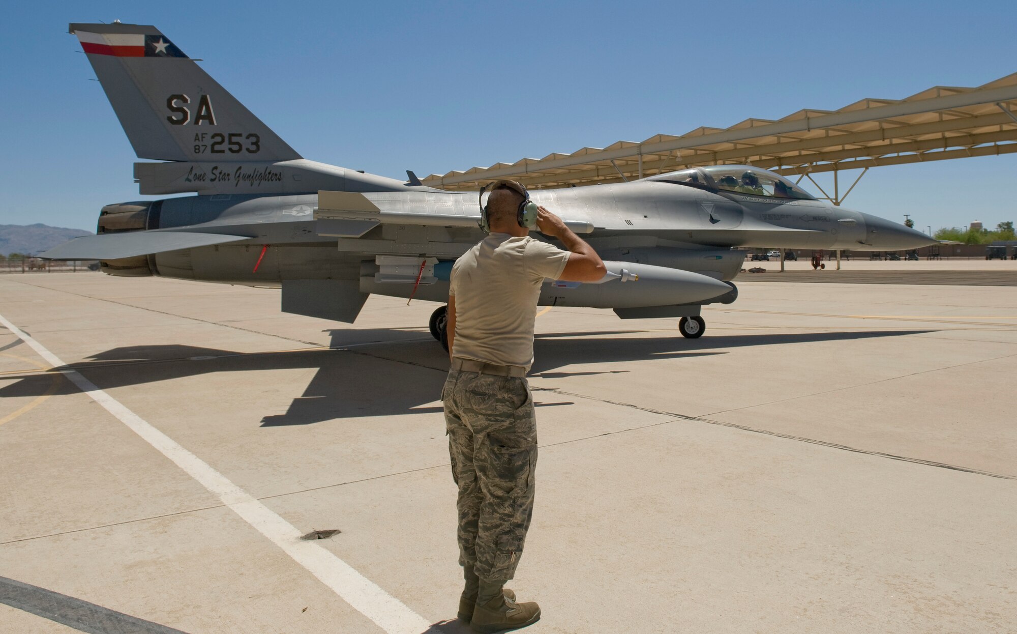 Senior Airman Jacob Rocha salutes as his jet departs for a training exercise during Exercise Coronet Cactus April 23 at Davis-Monthan Air Force Base, Ariz. Airman Rocha is assigned to the Texas Air National Guard’s 149th Fighter Wing from San Antonio, and is an F-16 Fighting Falcon crew chief. (U.S. Air Force photo/Master Sgt Jack Braden)
