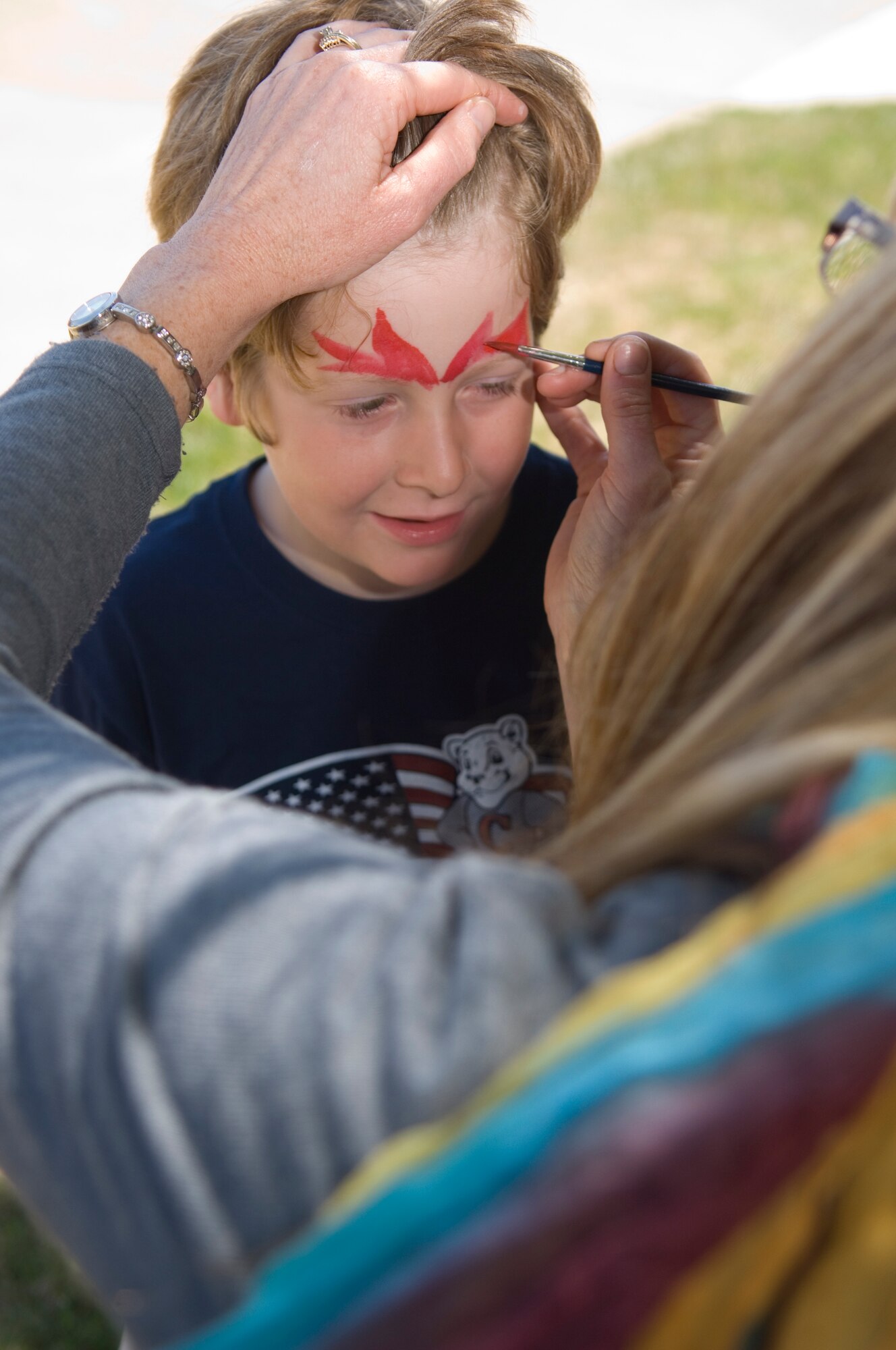 VANDENBERG AIR FORCE BASE, Calif. -- Getting into the Earth Day festivities, Roman Wankowski gets his face painted during the Earth Day Fair here April 22.  The fair had a barbecue and small activities for adults and children from face painting to spinning a wheel to win recyclable prizes. (U.S. Air Force photo/Airman 1st Class Andrew Lee)