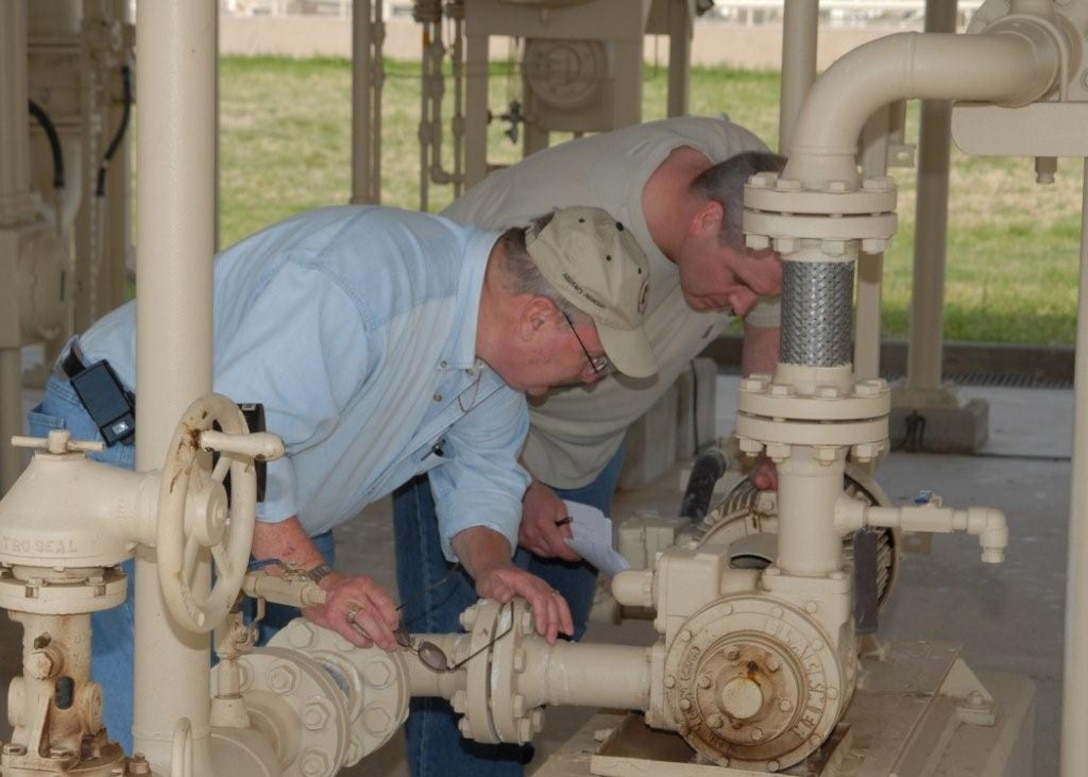 Tony Fischer of Air Force Petroleum Agency and Gerald Soper of Robert and Company examine the pipes of the Type Three Hydrant system at the Sheppard fuels training complex on April 23 during a baseline test. The test was part of the Air Force’s certification of synthetic fuels for the aircraft fleet. (U.S. Air Force Photo/LouAnne Sledge)  