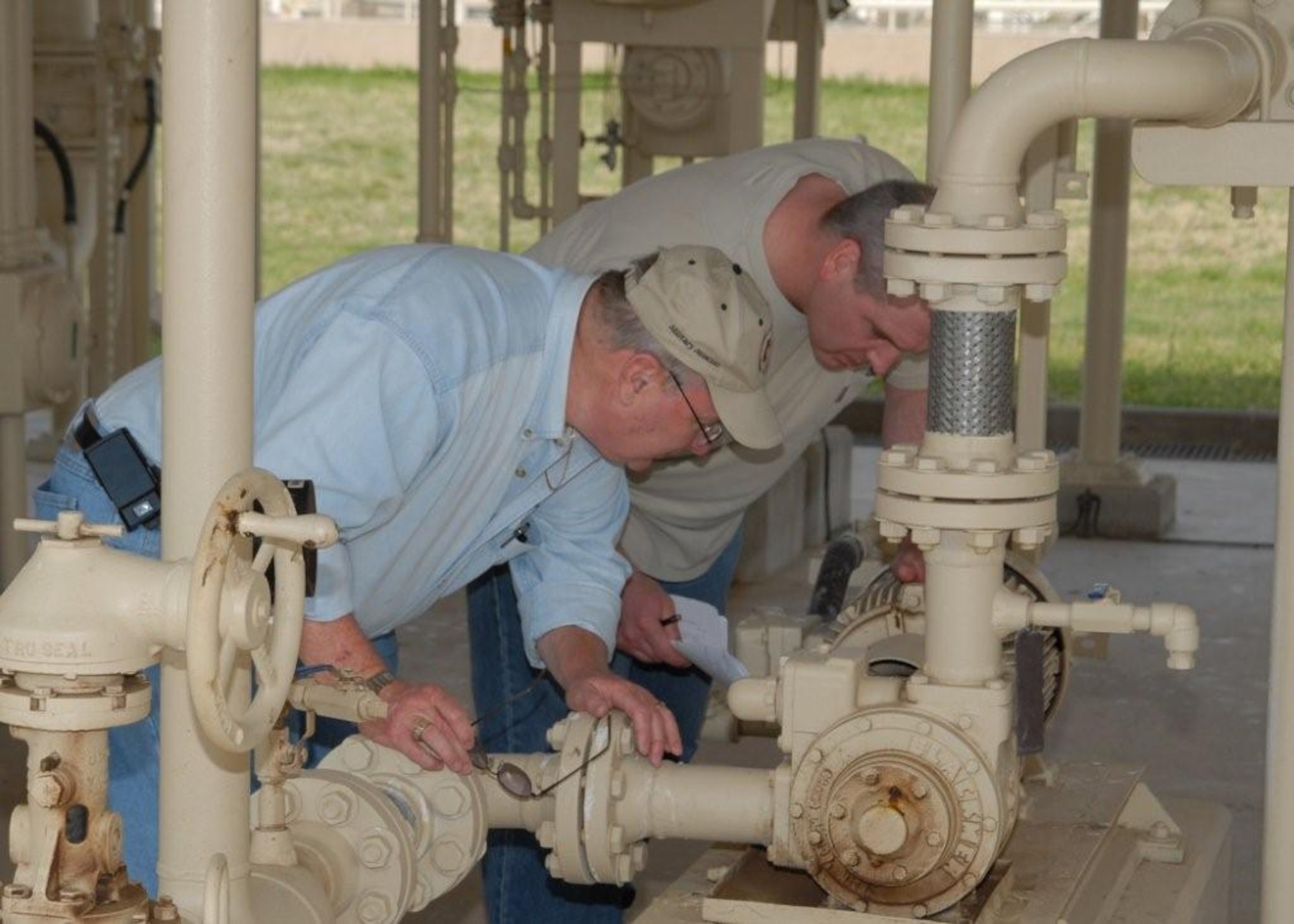 Tony Fischer of Air Force Petroleum Agency and Gerald Soper of Robert and Company examine the pipes of the Type Three Hydrant system at the Sheppard fuels training complex on April 23 during a baseline test. The test was part of the Air Force’s certification of synthetic fuels for the aircraft fleet. (U.S. Air Force Photo/LouAnne Sledge)  