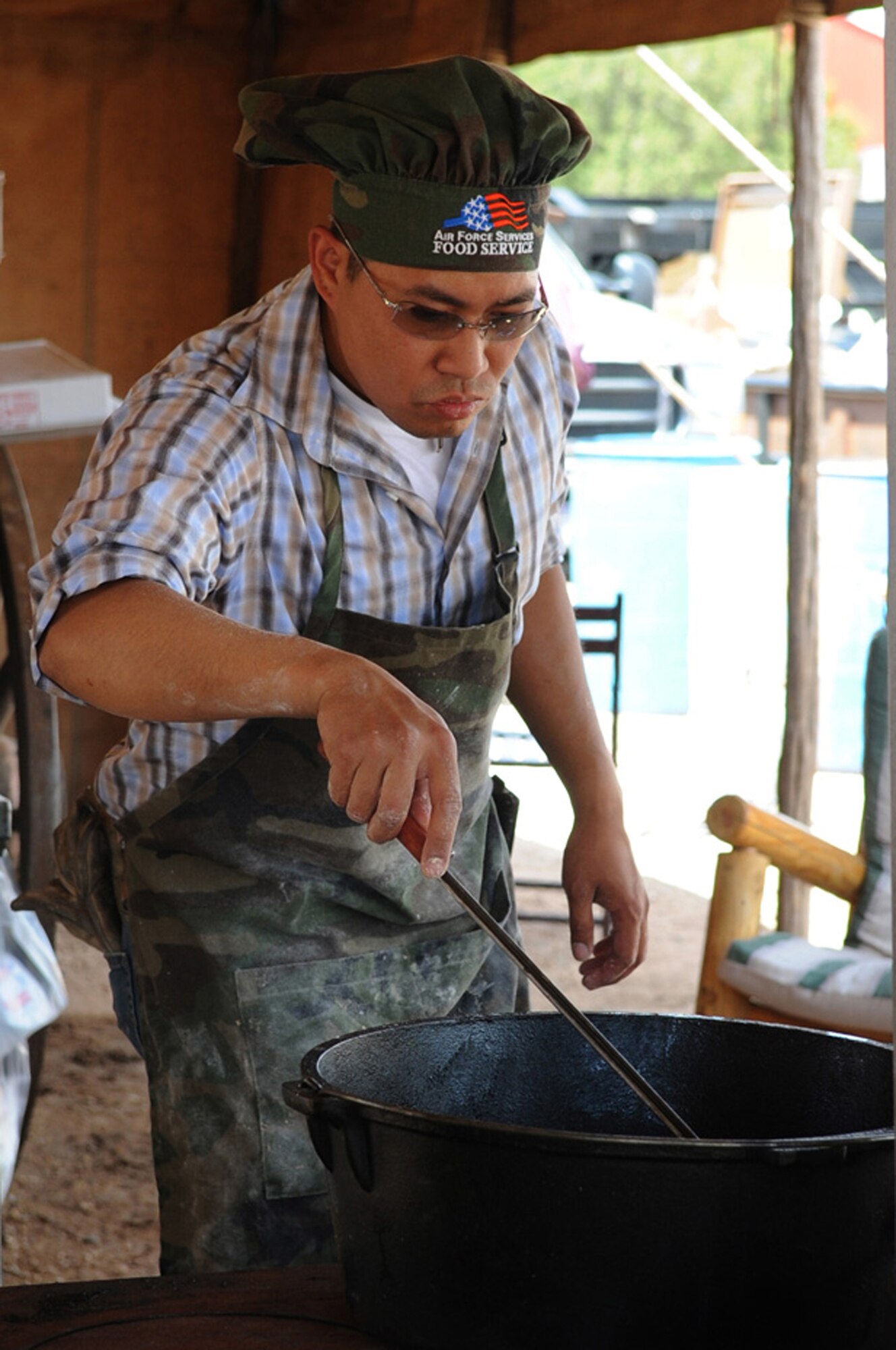 CANNON AIR FORCE BASE, N.M. -- Staff Sgt. Rhallete Javier, 27th Special Operations Civil Engineer Squadron, checks on a batch of chicken-fried steaks during the 2nd Annual 'Duke of the Dutch Ovens' Chuck Wagon Cook-Off April 25. Sergeant Javier participated on The Cannon Air Commando Wagon which tied for first place in the Meat Division.  (U.S. Air Force Photo/Staff Sgt. Heather Redman)
