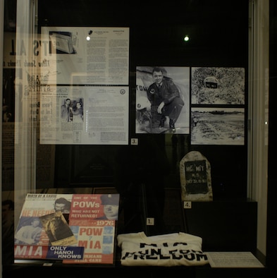 DAYTON, Ohio - This stone marked the grave of Col. Norman Schmidt in North Vietnam, and was returned to the U.S. with Schmidt's remains in 1974. Schmidt was shot down and captured in 1966. In 1967, he was taken from his cell, and fellow POWs never saw him again. After the war, the North Vietnamese showed U.S. experts graves of Americans who had died in captivity. One was marked by this stone—the initials "N.S." are for "Norman Schmidt. Also in the display case are bumper stickers, handouts and other items distributed to the public to remind them of those who never came home. POW/MIA advocates sponsored races in cities across the U.S. to remind the nation of unaccounted-for MIAs. Bob Schul, an Olympic distance runner, wore this jersey in the "MIA Run for Freedom" in Dayton, Nov. 17, 1973. (U.S. Air Force photo)