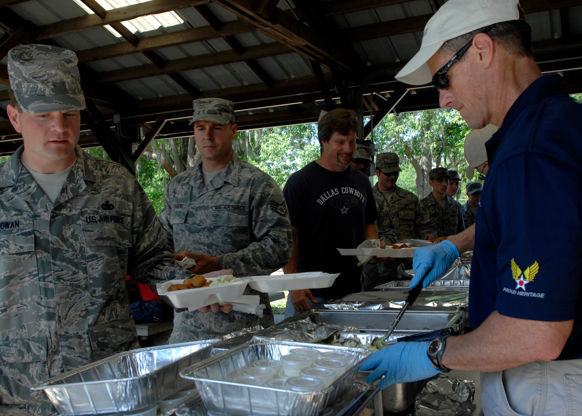 Chief Master Sgt. Benson Futrell serves Charleston Airmen food during the Chief's fish fry held at the picnic grounds here April 24. The fish fry is held annually to continue to unite the reserve and active-duty units on the base. Chief Futrell is the 315th Airlift Wing command chief. (U.S. Air Force photo/Senior Airman Katie Gieratz)
