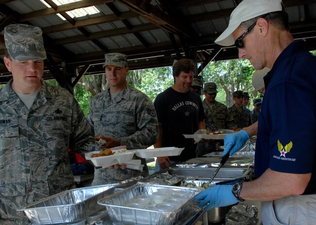Chief Master Sgt. Benson Futrell serves Charleston Airmen food during the Chief's fish fry held at the picnic grounds here April 24. The fish fry is held annually to continue to unite the reserve and active-duty units on the base. Chief Futrell is the 315th Airlift Wing command chief. (U.S. Air Force photo/Senior Airman Katie Gieratz)