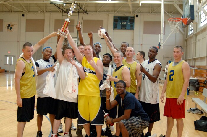 437th Civil Engineer Squadron celebrate their victory with the base trophy at the end of the base intramural basketball championship game at the Fitness and Sports Center here April 23. The 437 CES defeated the 437th Force Support Squadron 47-31 for the top spot. (U.S. Air Force photo/Staff Sgt. Marie Cassetty)(RELEASED)