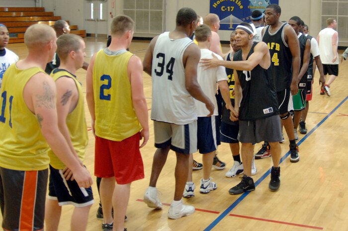 Team members of the 437th Force Support Squadron and 437th Civil Engineer Squadron congratulate each other on a well-played game at the end of the base intramural basketball championship game at the Fitness and Sports Center here April 23. The 437 CES defeated the 437 FSS 47-31 for the base championship. (U.S. Air Force photo/Staff Sgt. Marie Cassetty)(RELEASED)