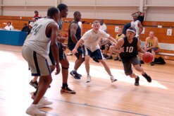 La'Quin Mims tries to get past 437th Civil Engineer Squadron defenders during the base intramural basketball championship game at the Fitness and Sports Center here April 23. The 437 CES defeated the 437th Force Support Squadron 47-31 for the base championship. Mims is assigned to the 437 FSS. (U.S. Air Force photo/Staff Sgt. Marie Cassetty)(RELEASED)