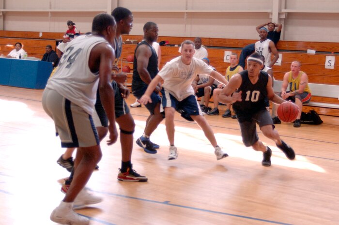 La'Quin Mims tries to get past 437th Civil Engineer Squadron defenders during the base intramural basketball championship game at the Fitness and Sports Center here April 23. The 437 CES defeated the 437th Force Support Squadron 47-31 for the base championship. Mims is assigned to the 437 FSS. (U.S. Air Force photo/Staff Sgt. Marie Cassetty)(RELEASED)