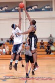 Jeston Freeman, left, and Robert Green, right, jump for the tip off ball at the start of the base intramural basketball championship game at the Fitness and Sports Center here April 23. Freeman scored a total of nine points during the game and was the second highest scorer for his team. The 437th Civil Engineer Squadron defeated the 437th Force Support Squadron 47-31. Freeman is assigned to the 437 CES and Green is assigned to the 437 FSS. (U.S. Air Force photo/Staff Sgt. Marie Cassetty)(RELEASED)