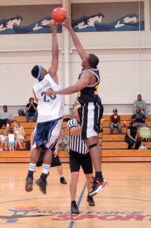 Jeston Freeman, left, and Robert Green, right, jump for the tip off ball at the start of the base intramural basketball championship game at the Fitness and Sports Center here April 23. Freeman scored a total of nine points during the game and was the second highest scorer for his team. The 437th Civil Engineer Squadron defeated the 437th Force Support Squadron 47-31. Freeman is assigned to the 437 CES and Green is assigned to the 437 FSS. (U.S. Air Force photo/Staff Sgt. Marie Cassetty)(RELEASED)