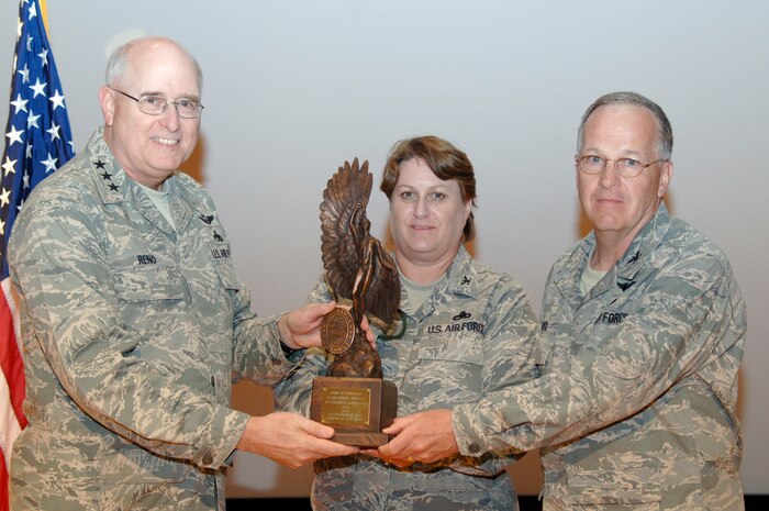 Lt. Gen. Loren Reno presents the Daedalian Trophy to Cols. Tammy Livingood and James Joyce during a presentation ceremony at the base theater April 24. General Reno presented the Daedalian Trophy to the 437th and 315th Maintenance Groups for being the best in the Air Force. General Reno is the deputy chief of staff for Logistics, Installations and Mission Support at the Pentagon. Colonel Livingood is the 437 MXG commander and Colonel Joyce is the 315 MXG commander. (U.S. Air Force photo/Staff Sgt. Marie Cassetty)(RELEASED)