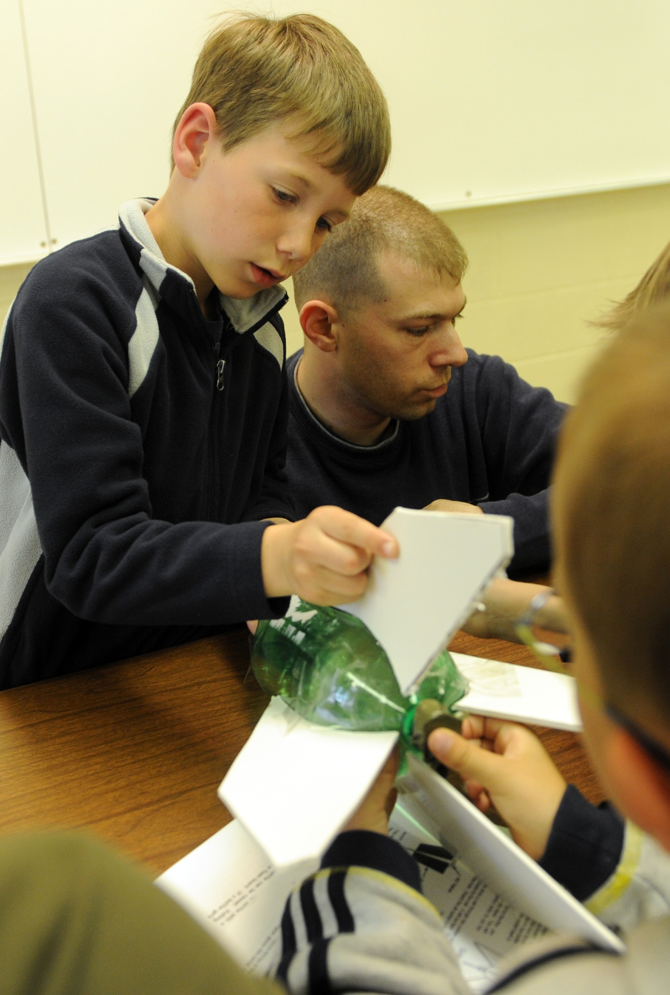 MOUNTAIN HOME AIR FORCE BASE, Idaho -- Peyton Sexton, a second grade student from the base primary school, builds a rocket with the help of classmates and volunteers April 24. Students learned the fundamentals of rocketry, and then put the lesson to use by building rockets and launching them in front of the school. The event was part of the school’s annual science day event that included hands-on lessons in various scientific fields as well as guest speakers from the 366th Medical Group and the Bureau of Land Management. (U.S. Air Force photo by Airman 1st Class Debbie Lockhart)
