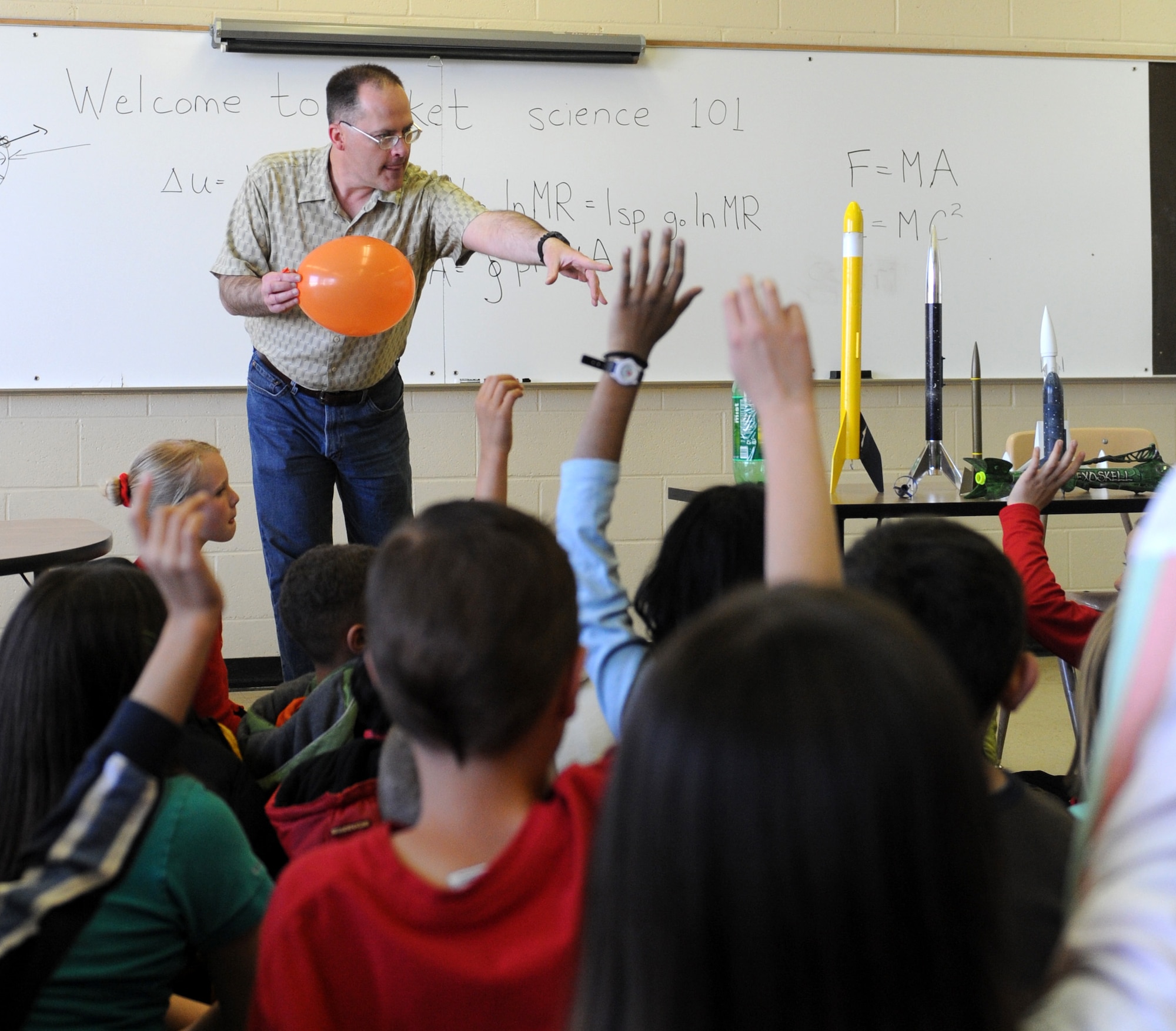 MOUNTAIN HOME AIR FORCE BASE, Idaho -- Master Sgt. Brian Orban, 366th Fighter Wing Public Affairs Office superintendent, teaches a lesson on rocket science to students from the base primary school April 24. Students learned the fundamentals of rocketry, and then put the lesson to use by building rockets and launching them in front of the school. The event was part of the school’s annual science day event that included hands-on lessons in various scientific fields as well as guest speakers from the 366th Medical Group and the Bureau of Land Management. (U.S. Air Force photo by Airman 1st Class Debbie Lockhart)